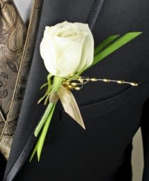 White rose boutonniere on a dark suit jacket