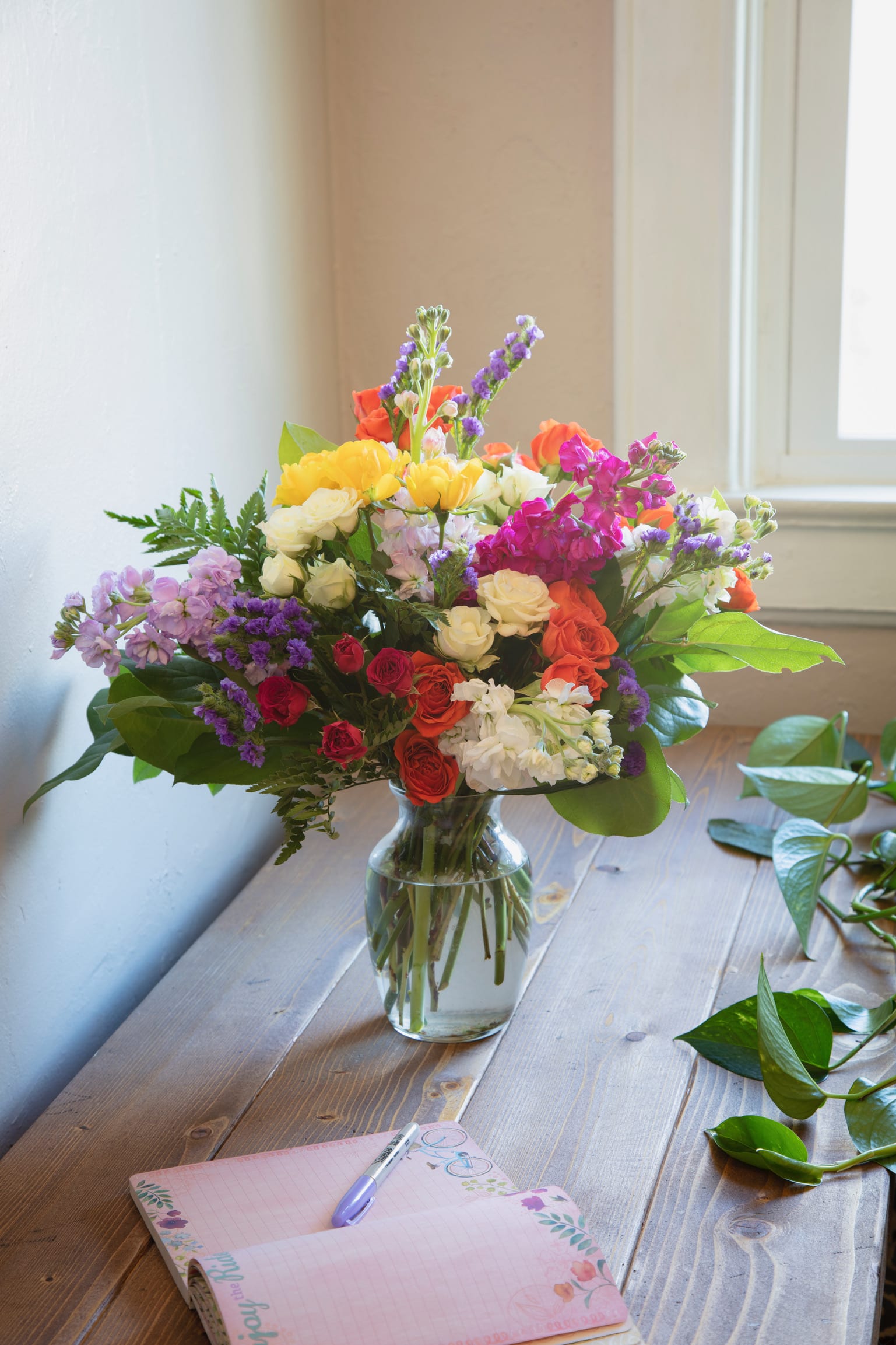 Mixed bouquet of colorful flowers in a clear glass vase