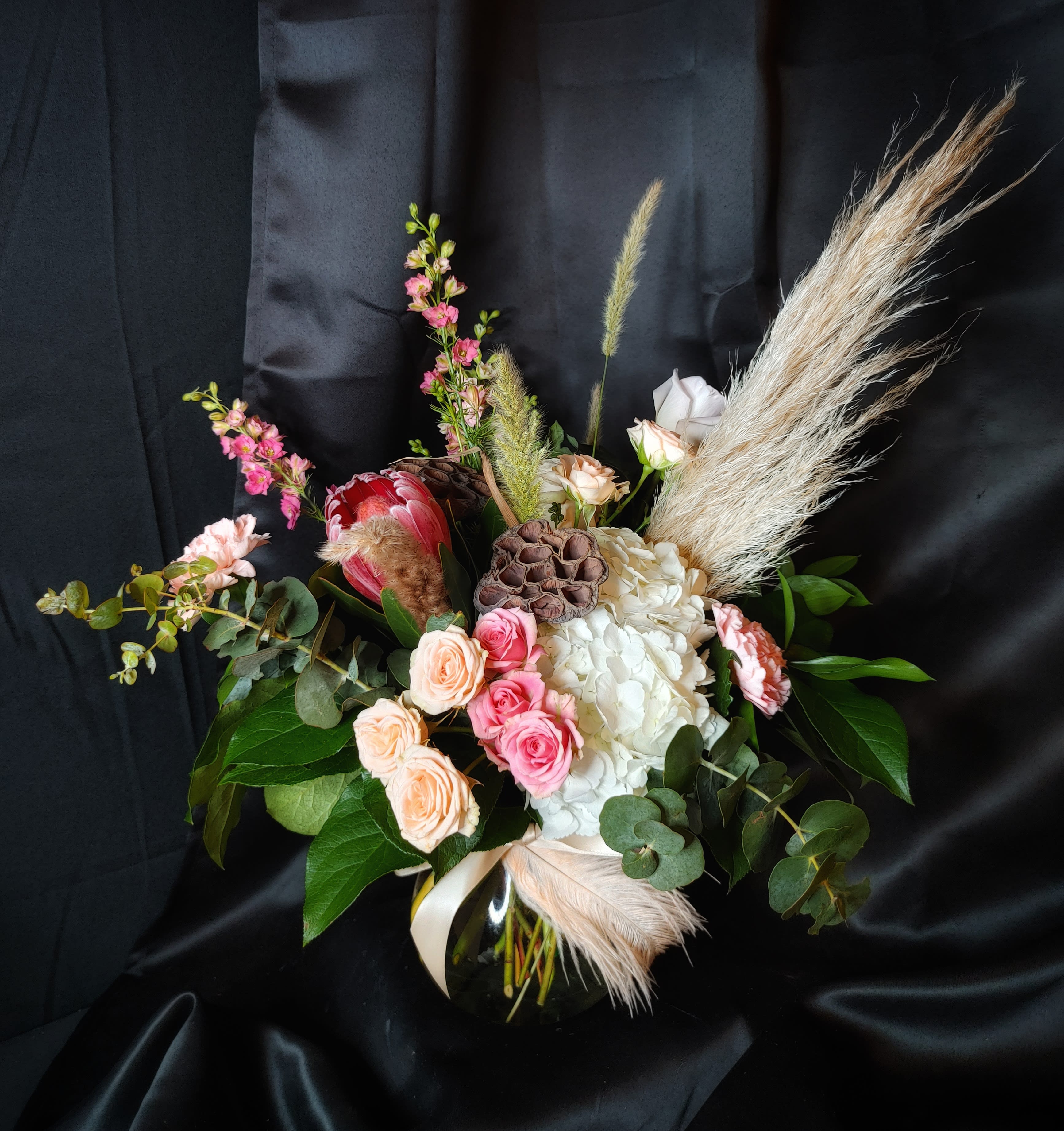 Mixed bouquet in a black vase with pink and white flowers