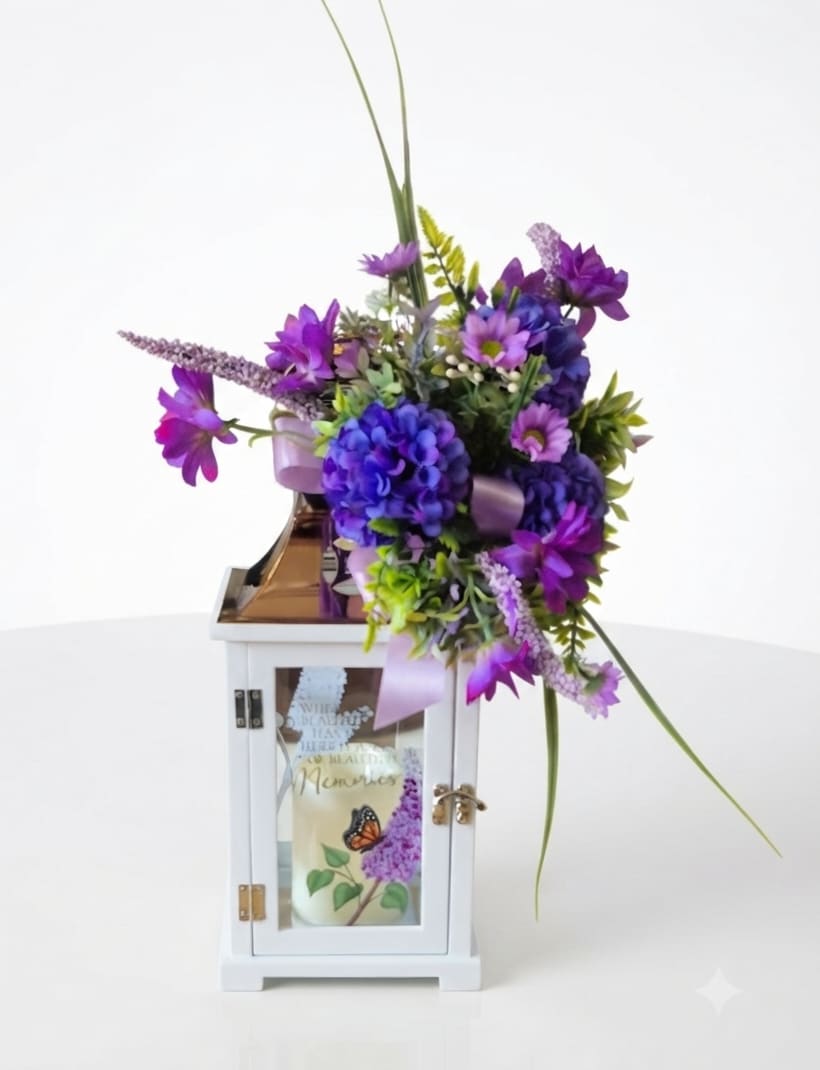 Purple floral arrangement in a white lantern with a candle inside