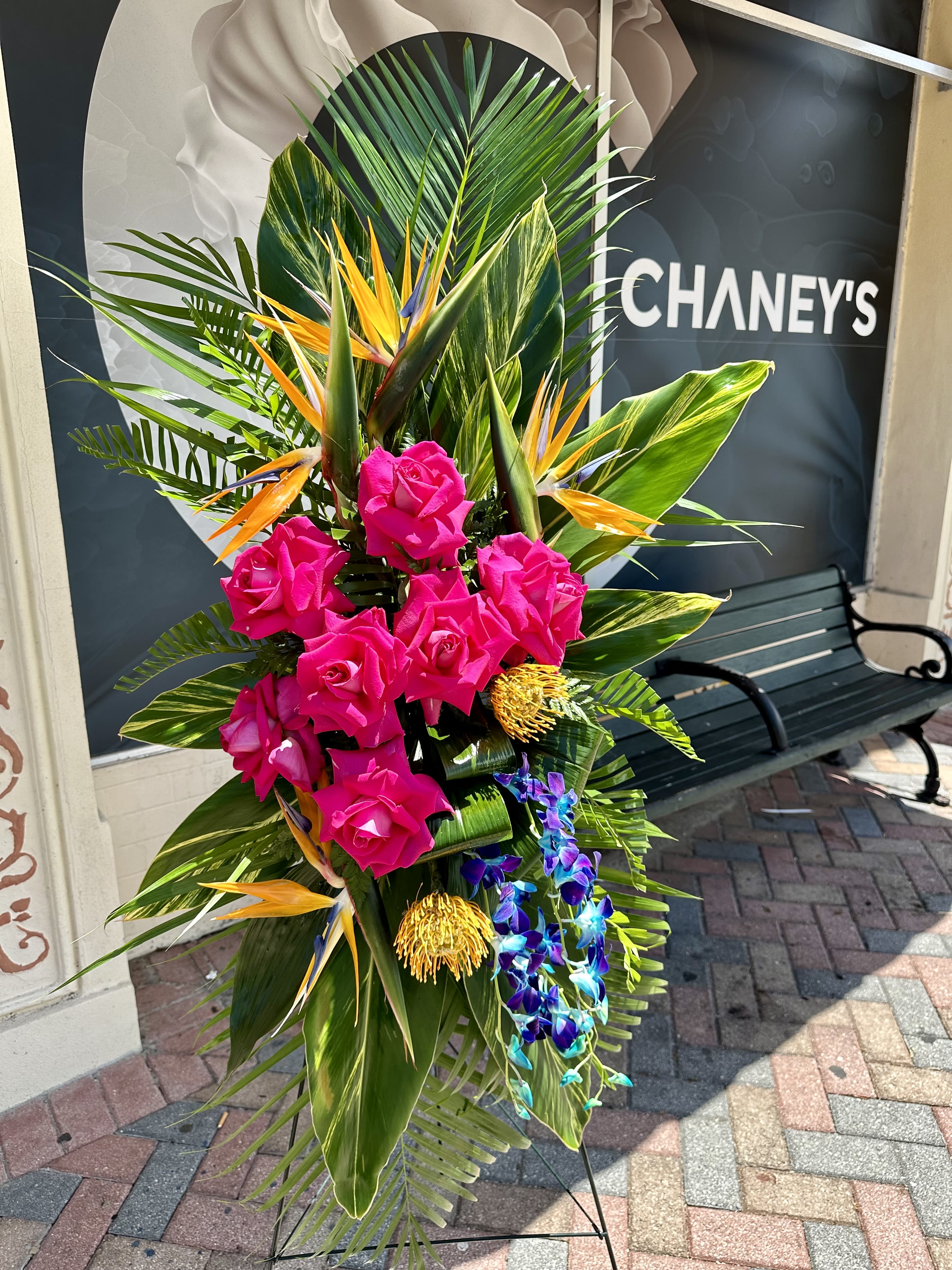 Tall tropical arrangement with pink roses and orchids