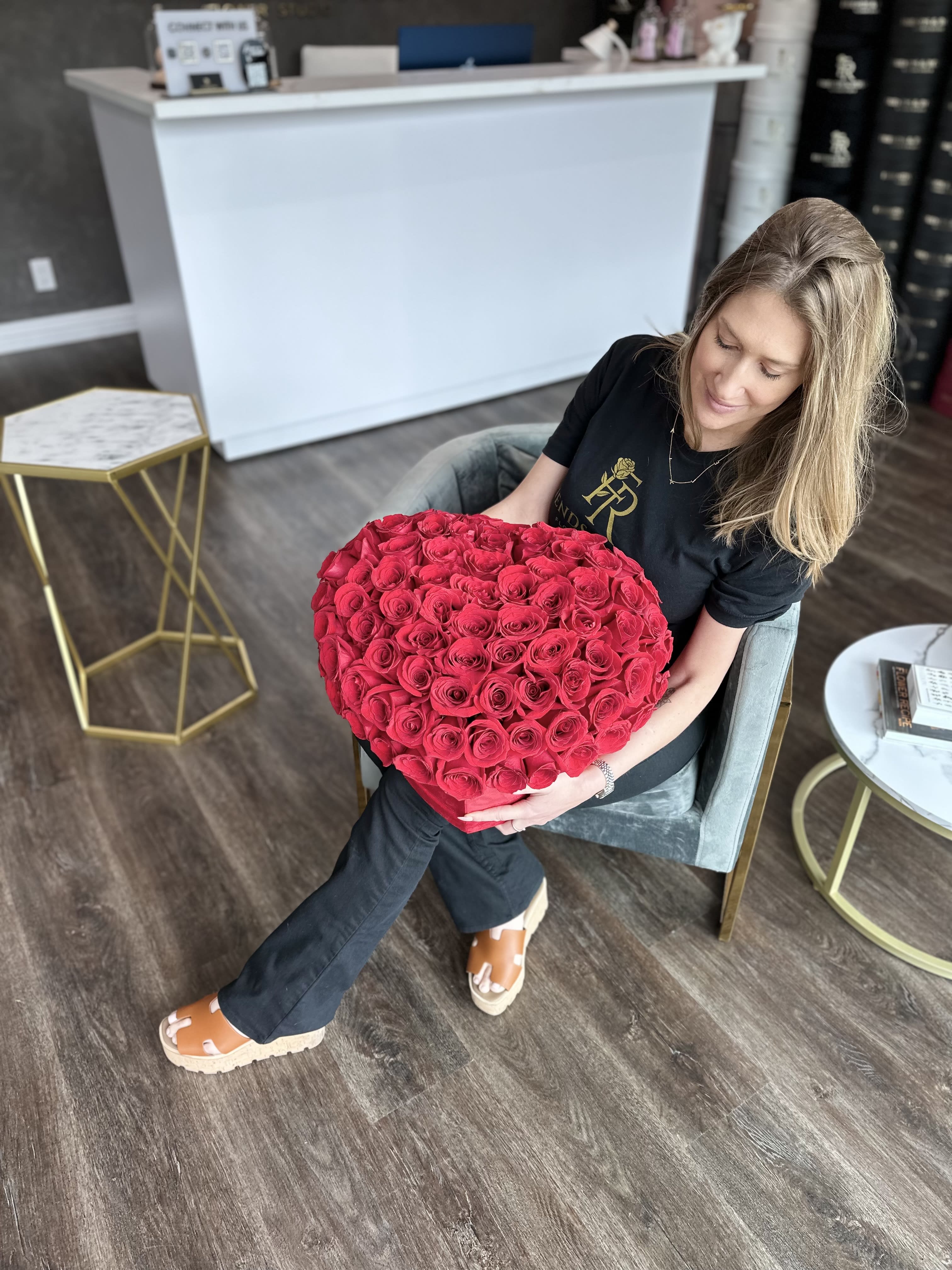 Woman holding a large heart-shaped bouquet of red roses
