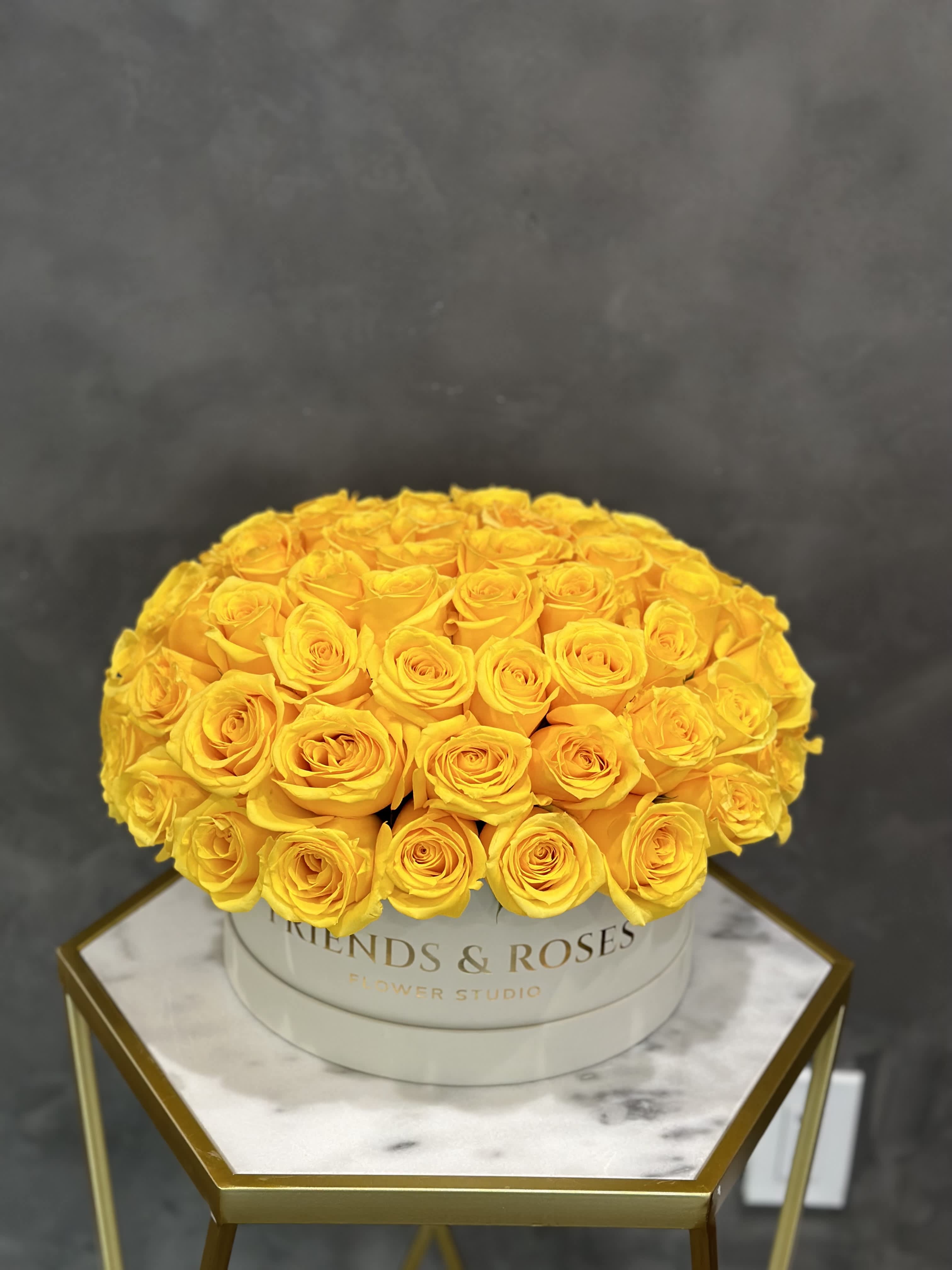 Round bouquet of yellow roses in a white hat box