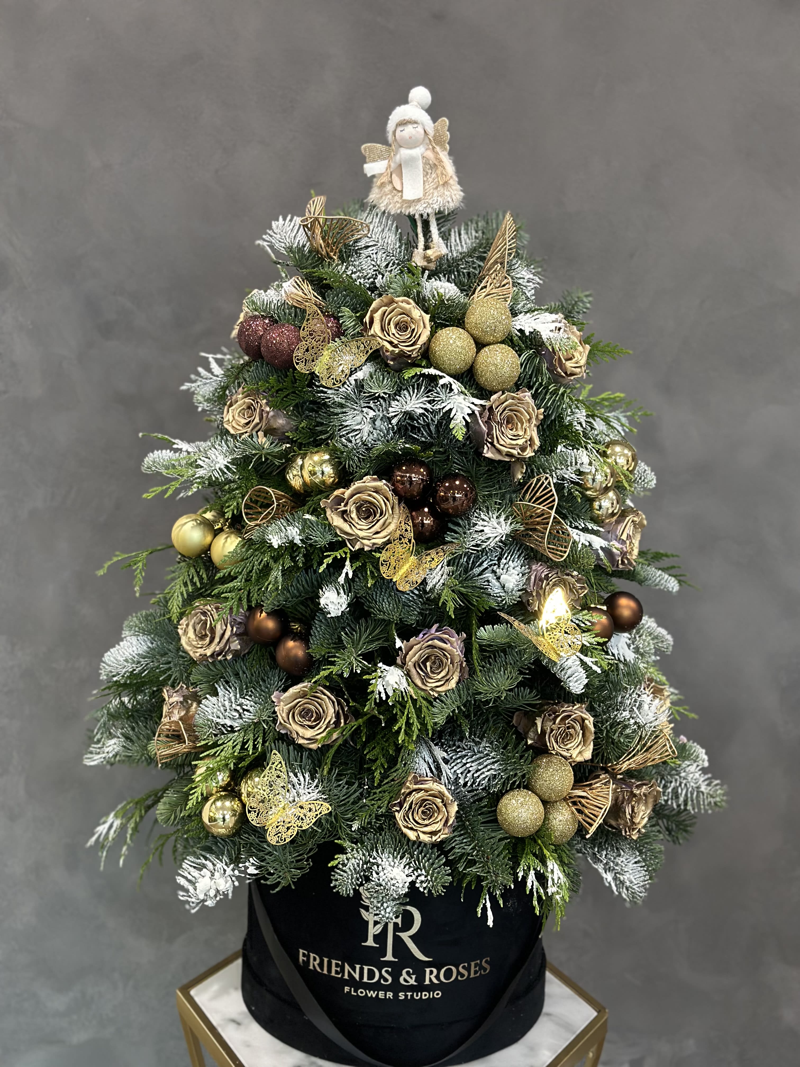 Christmas tree arrangement with gold roses and ornaments in a black box