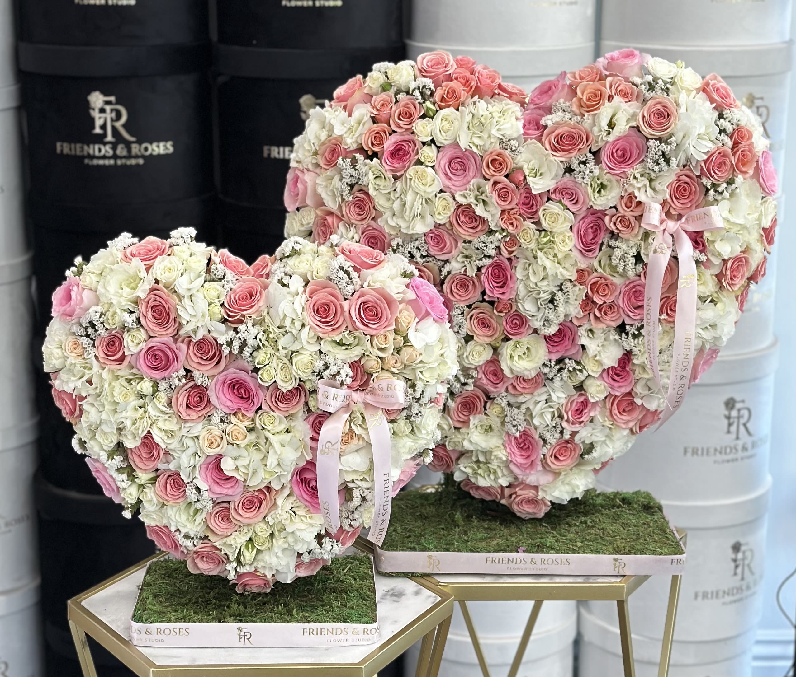 Heart-shaped rose arrangements in pink and white on gold stands