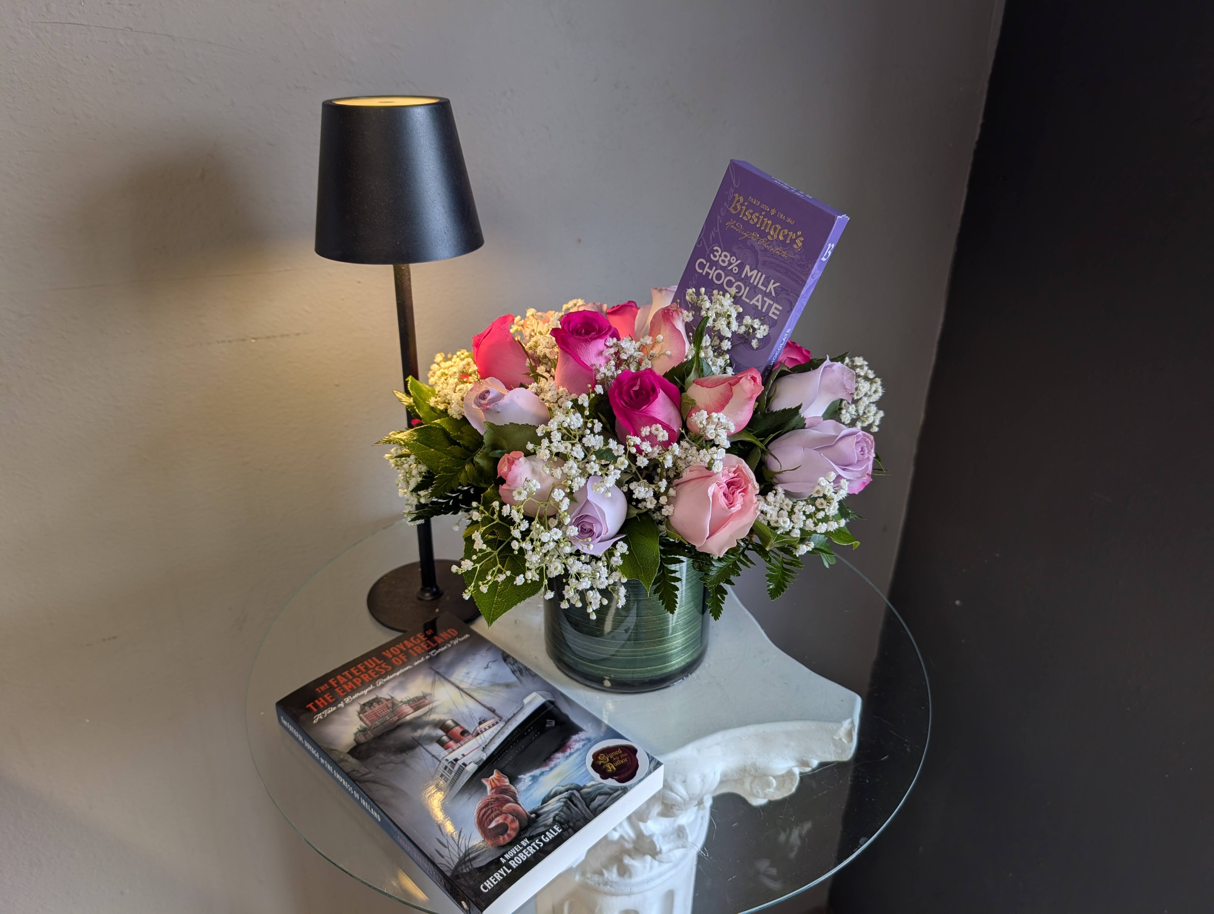 Midnight book club Package (flowers and gifts)  -  A vase arrangement of roses, light, book and candy. It's a perfect get away to take a break and relax.  Book: The Fateful Voyage of the Empress of Ireland.  London, 1965: for Captain Henry Kendall, the burden of silence has become unbearable. On his deathbed, he confides in the kind young nurse caring for him, unknowing of their shared connection. Thus, the tales of a colorful past submerge, including a notorious murder and the unbearable scenes of the purported cursed 'Empress of Ireland' as it slipped beneath the surface of the icy St. Lawrence River in 1914. nearly a century later, an article sends shockwaves through the nation. Could history have gotten it wrong, and an innocent man hanged?