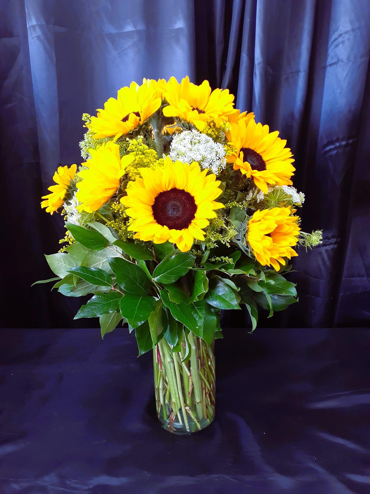 Bouquet of yellow sunflowers in a clear glass vase