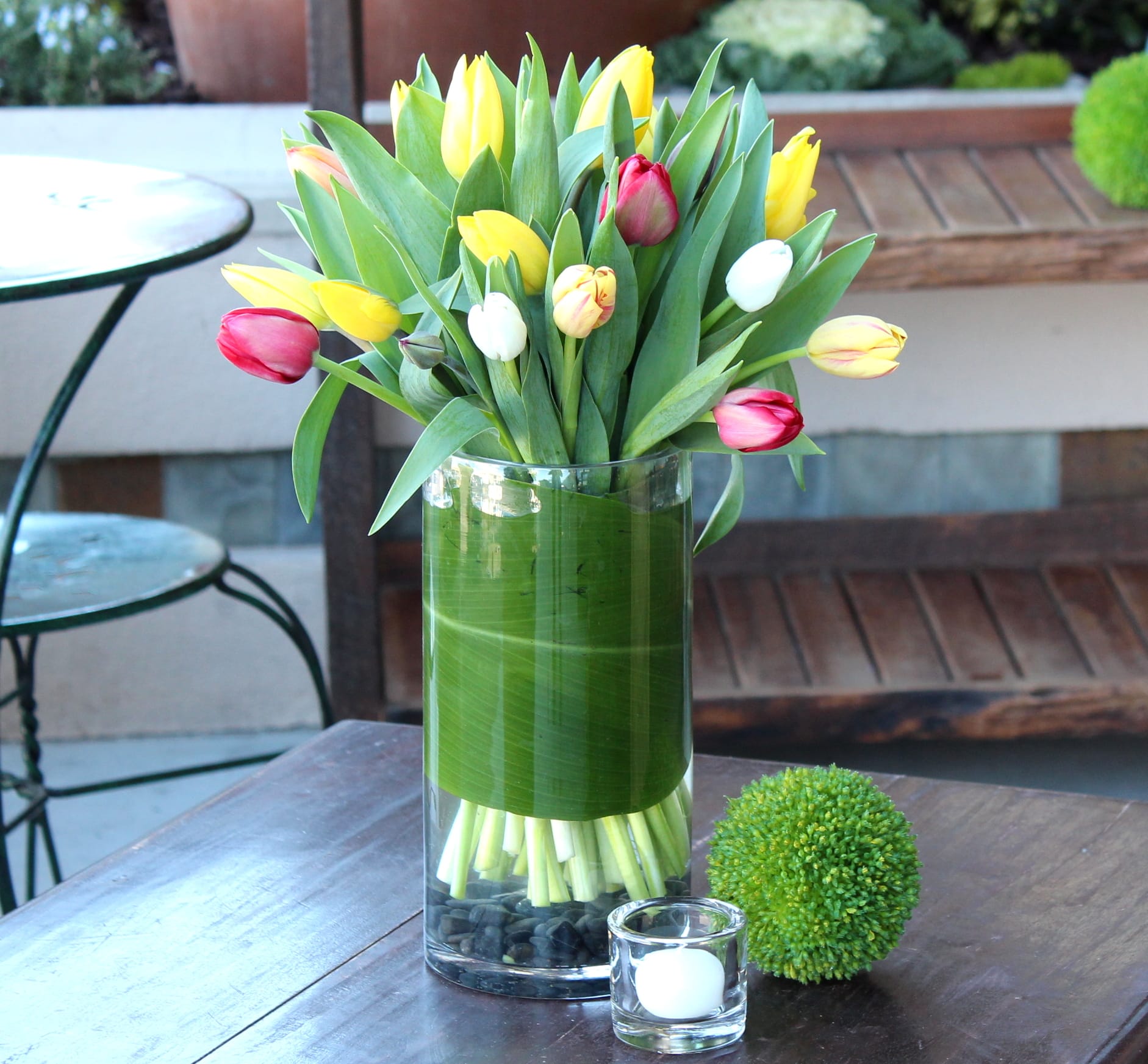 Tulip bouquet in a clear glass vase with a green wrap