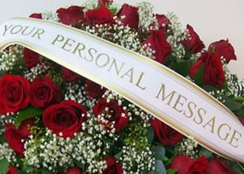 Red roses with baby's breath and a memorial ribbon