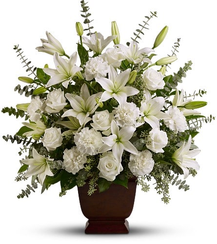 White lilies and roses arranged in a dark urn vase