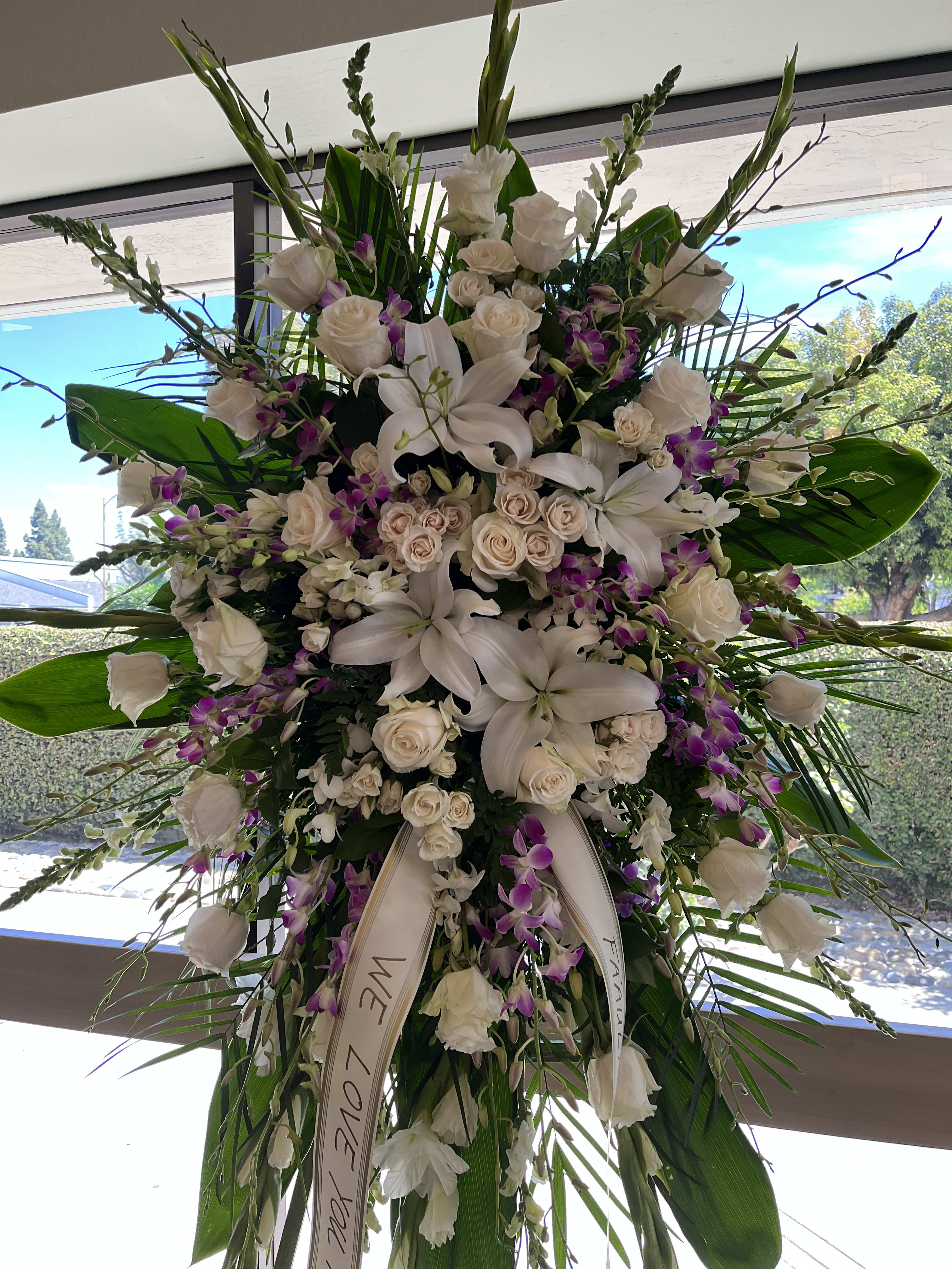 Large white floral standing spray with roses and lilies