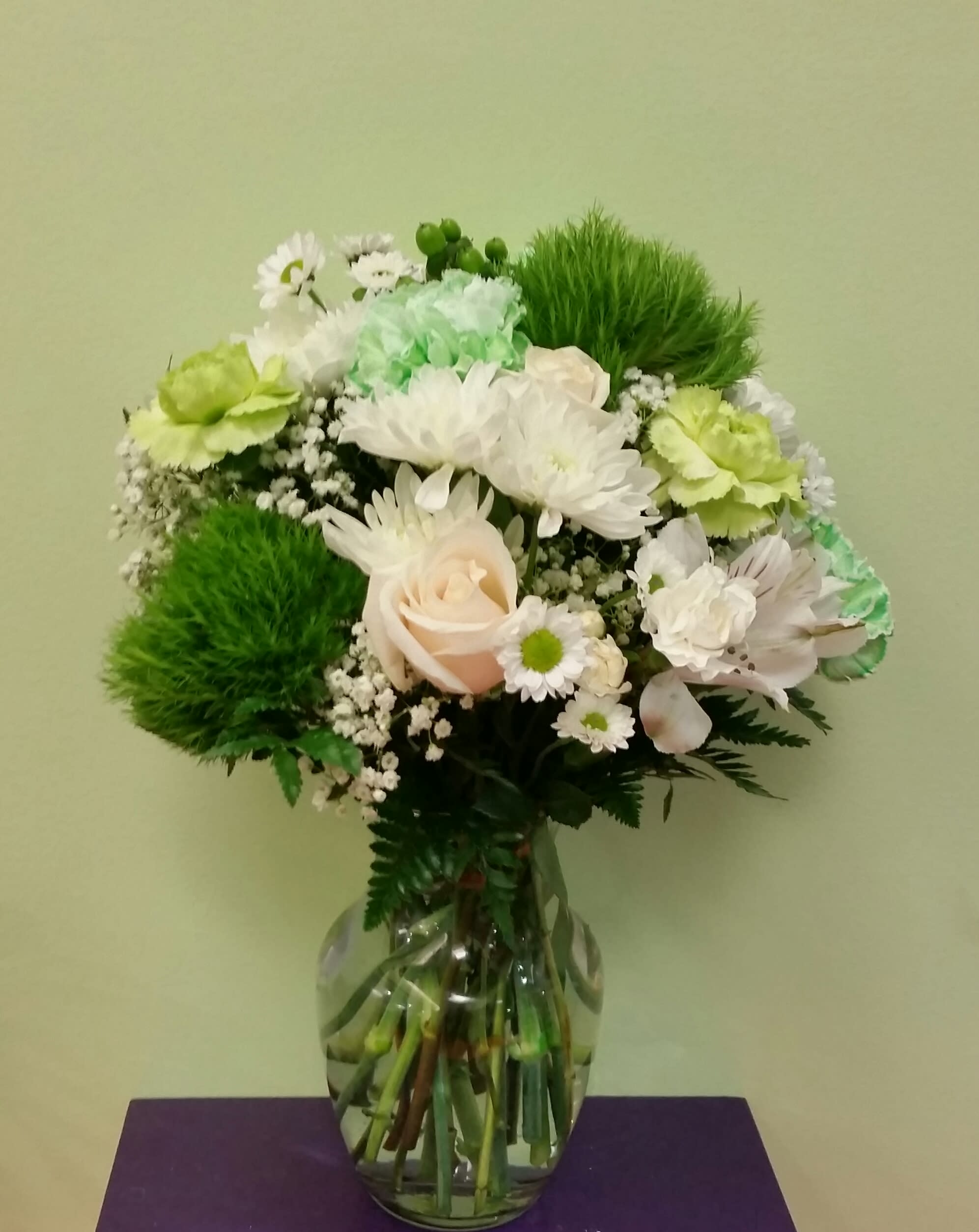 Bouquet of white and green flowers in a clear glass vase