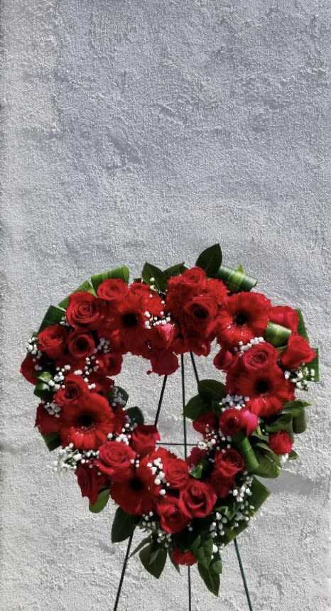 Heart-shaped red flower wreath on a stand