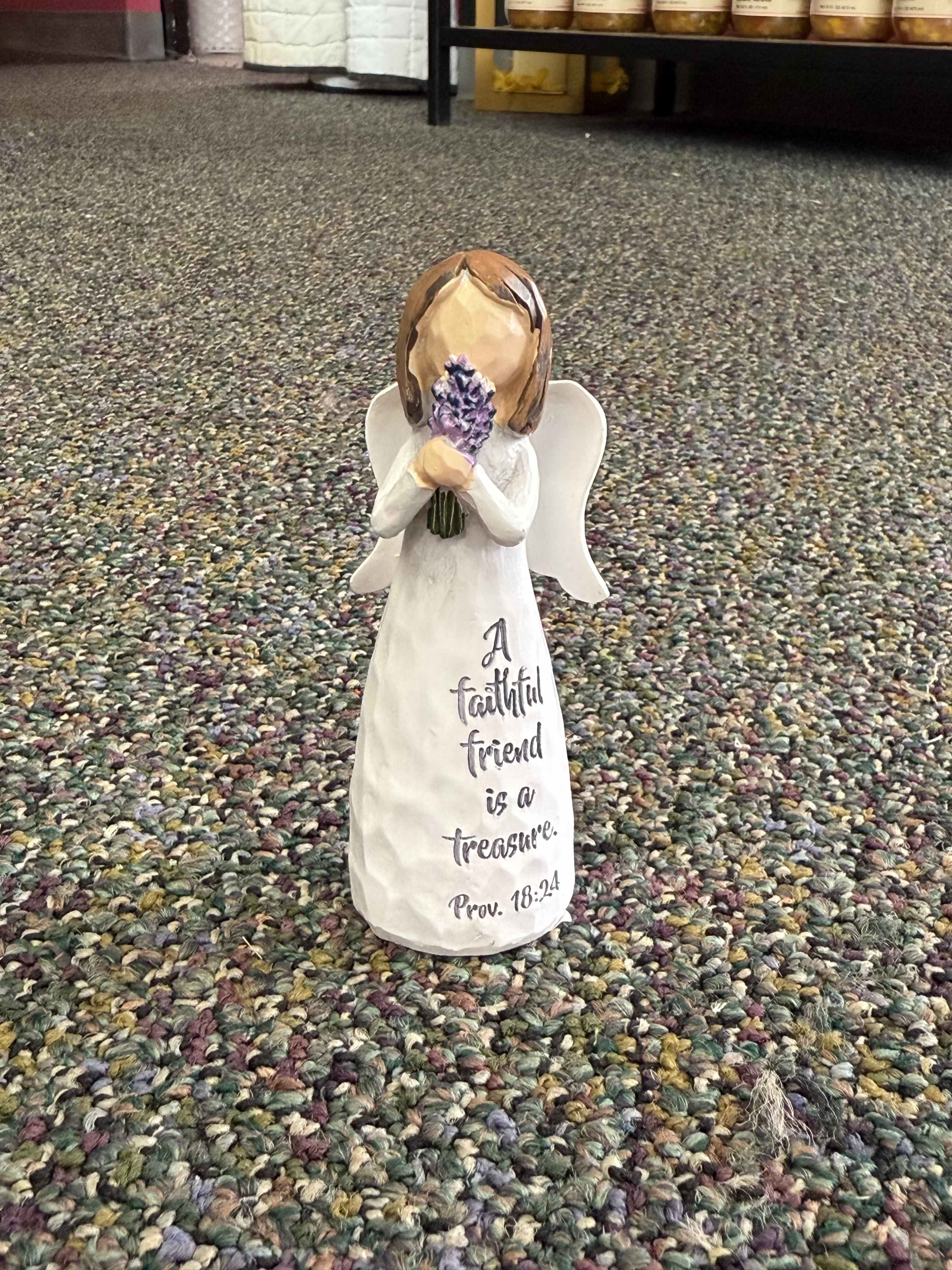 Small angel figurine holding purple flowers