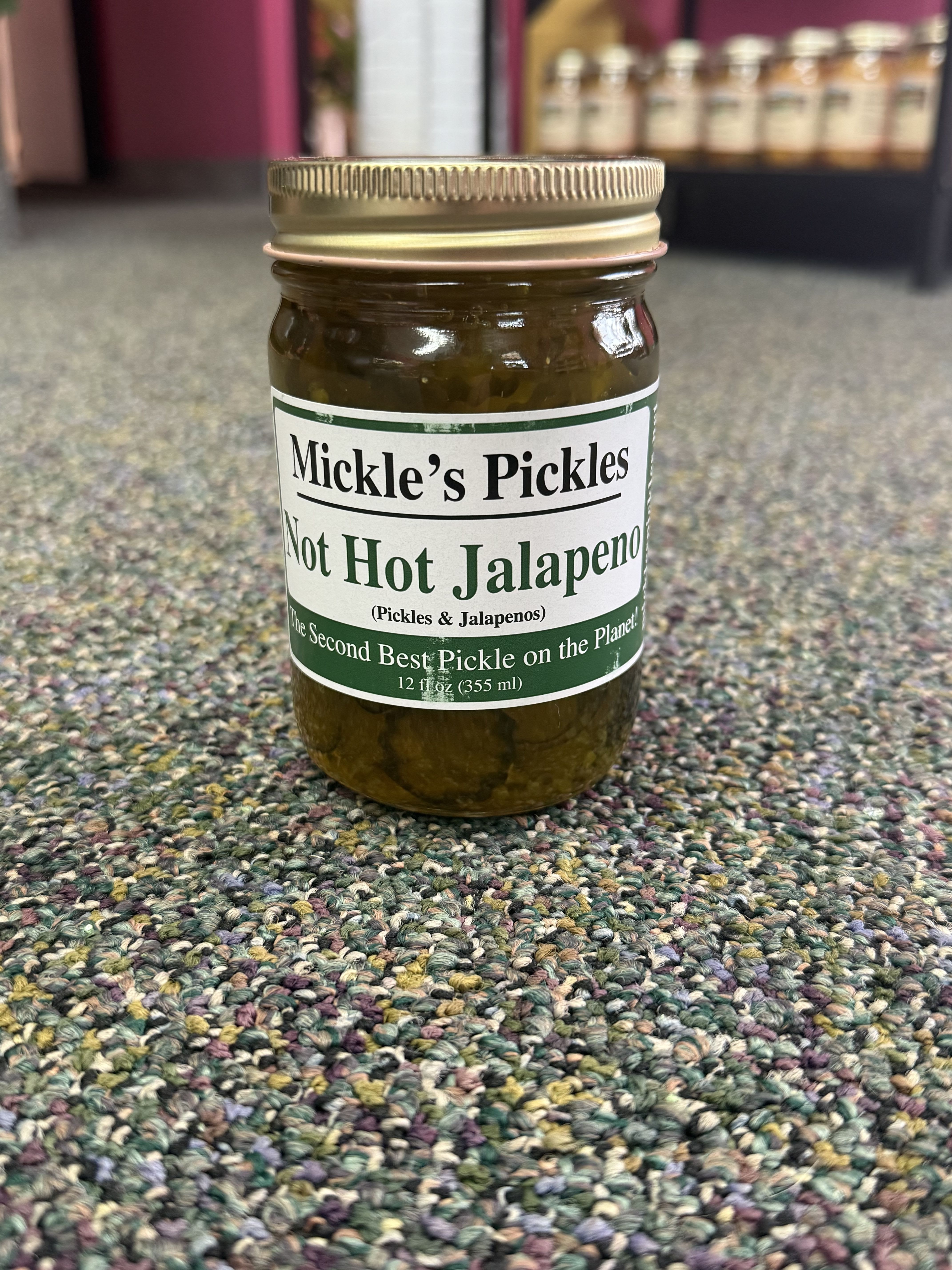 Jar of pickles labeled "Mickle's Pickles" on a carpeted floor