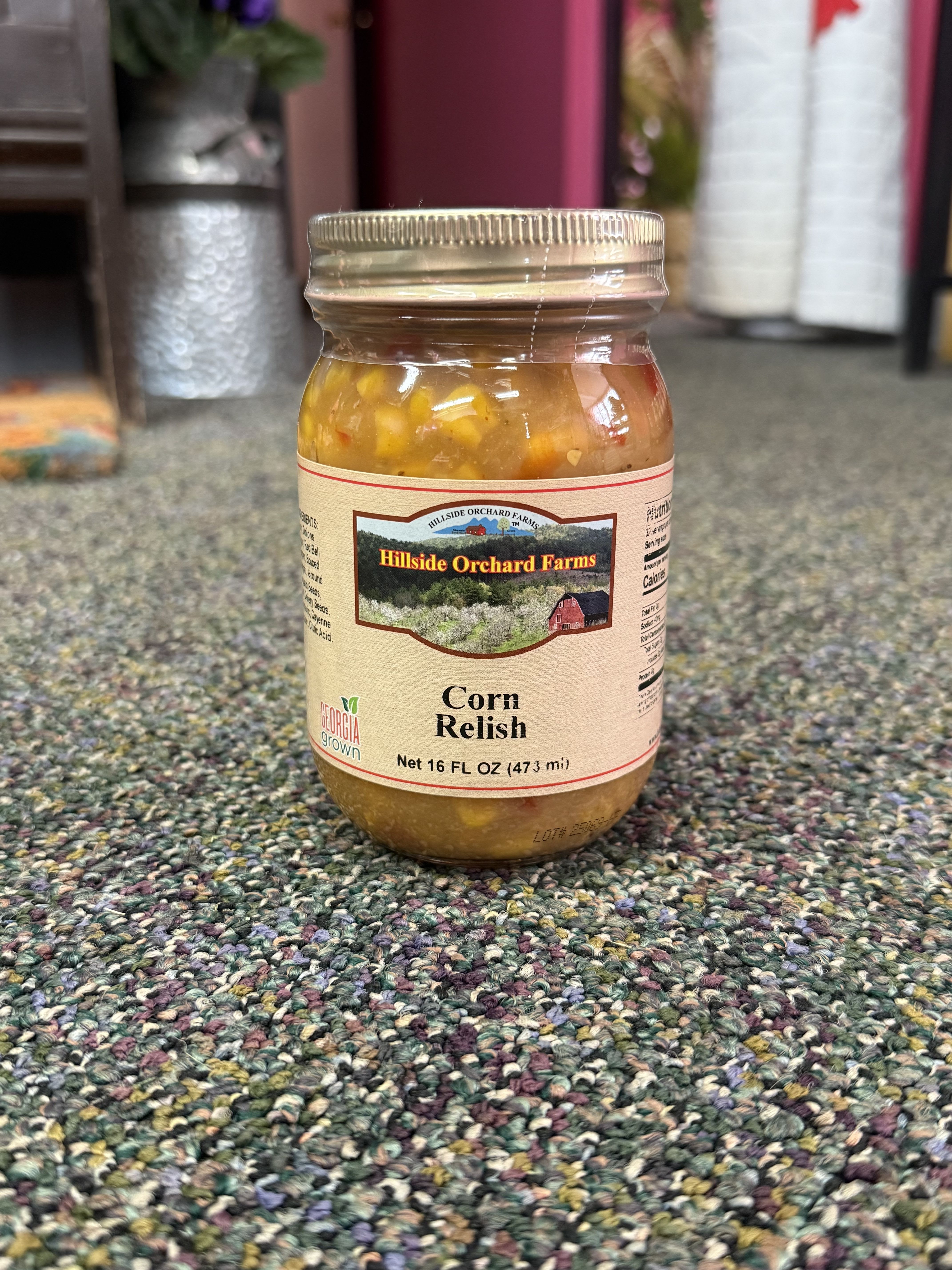 Jar of corn relish with a metal lid on carpet
