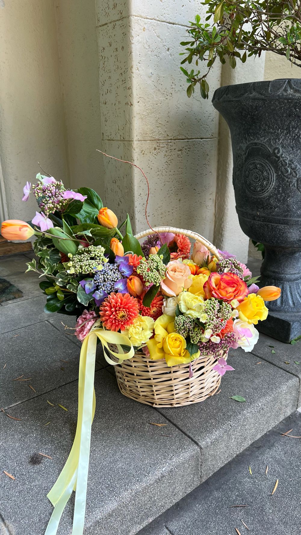 Basket of colorful mixed flowers with a ribbon bow