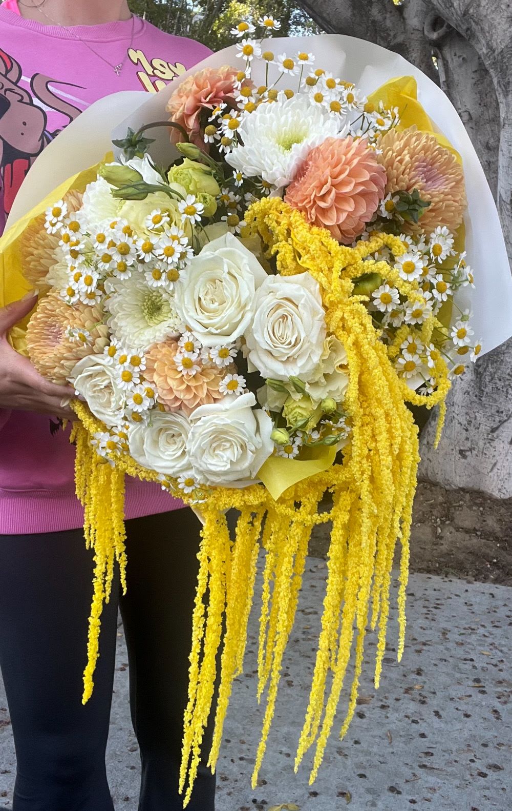 Large bouquet of white, peach, and yellow flowers with cascading yellow strands