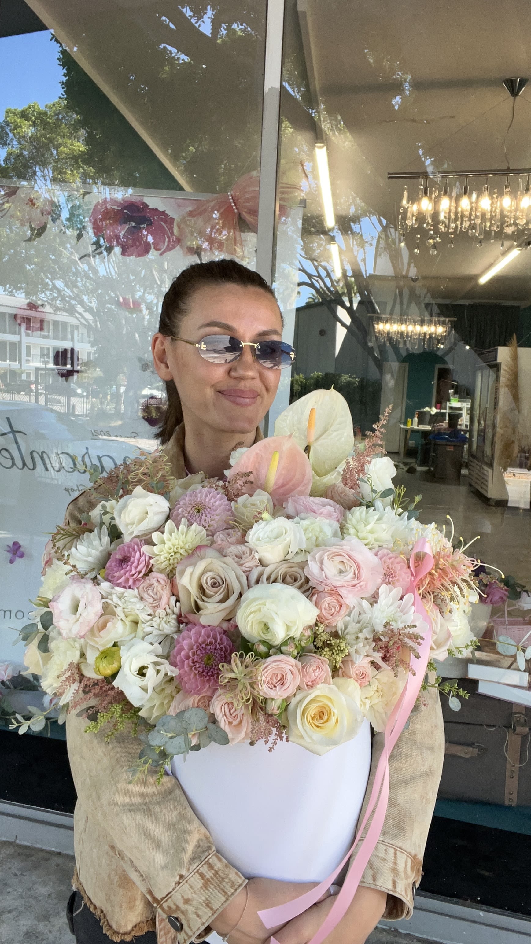 Woman holding a large pastel bouquet in a white box