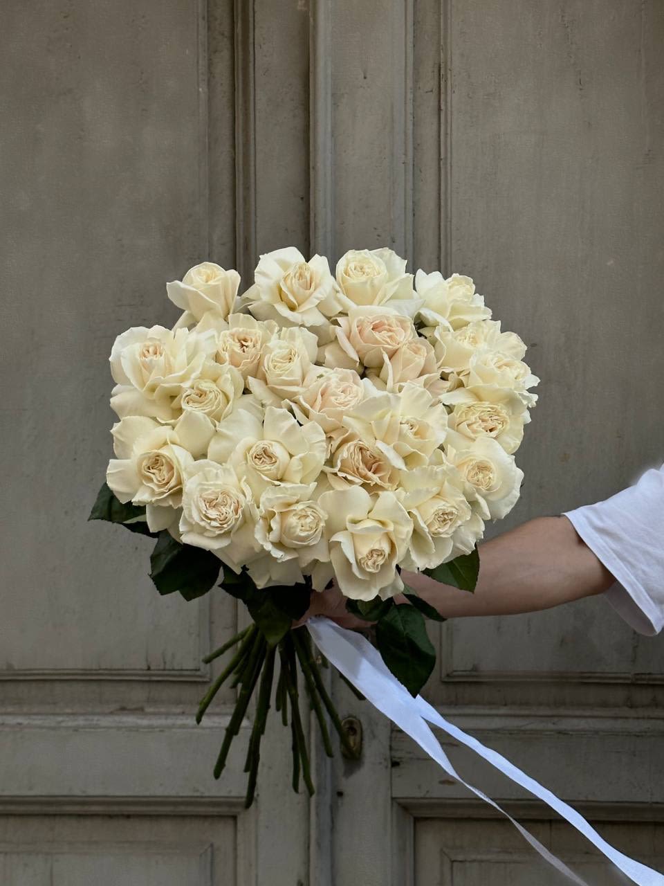 Bouquet of cream roses tied with a white ribbon