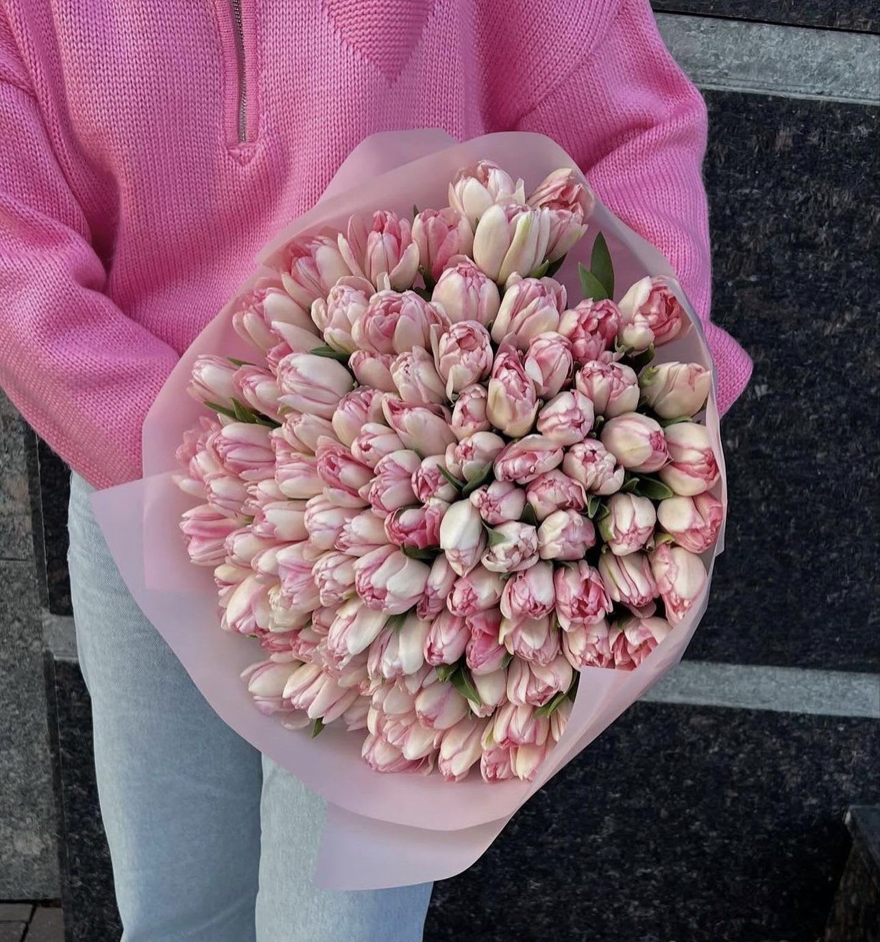 Bouquet of pink and white tulips wrapped in pale pink paper