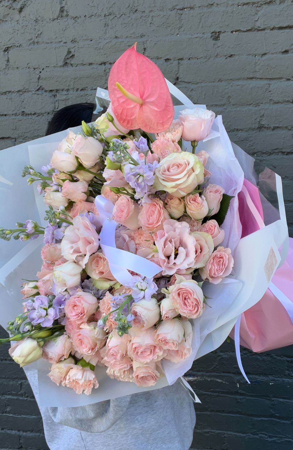 Large pastel bouquet with pink roses and a pink anthurium bloom
