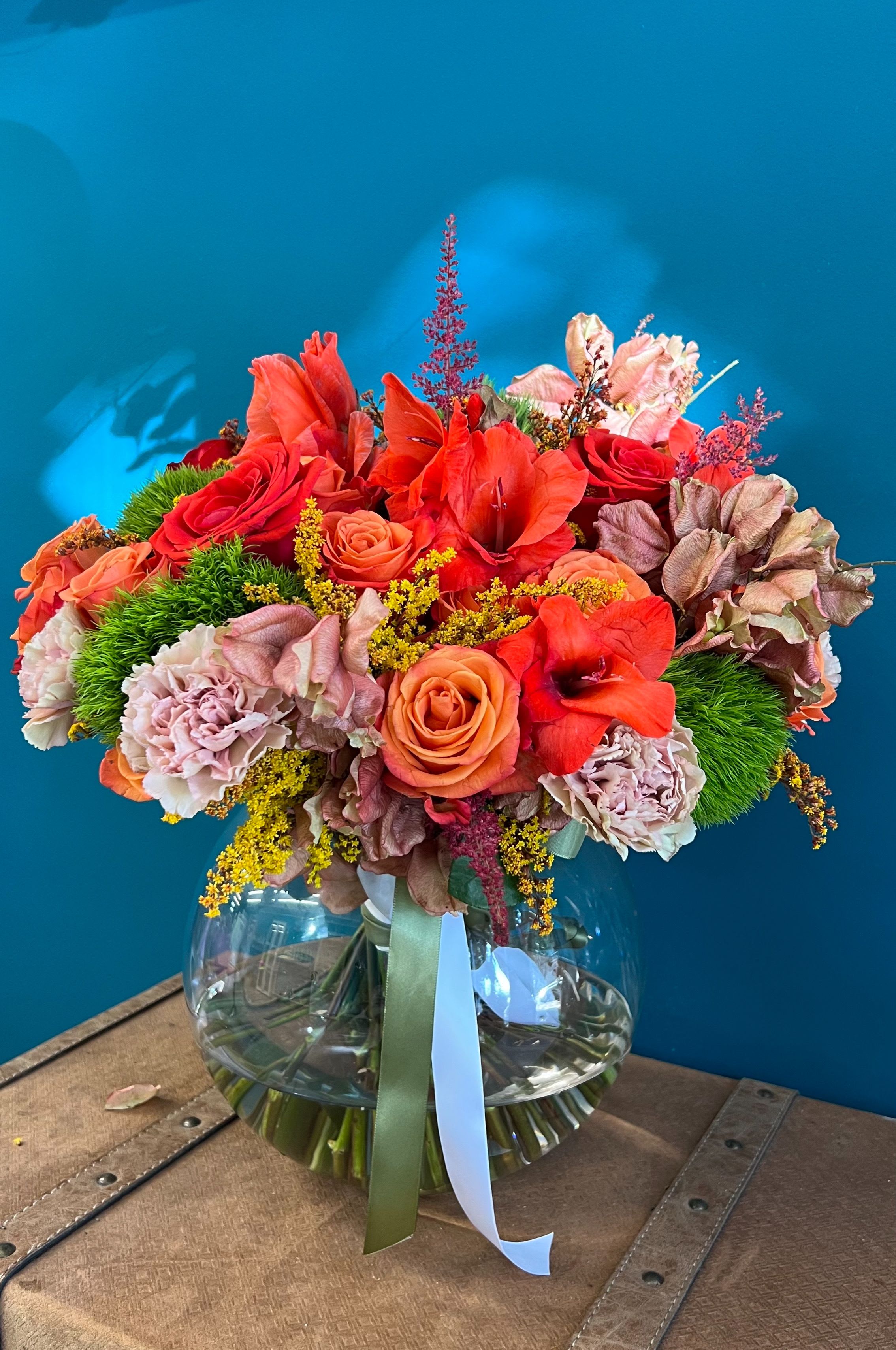 Bouquet of red and peach flowers in a clear glass vase