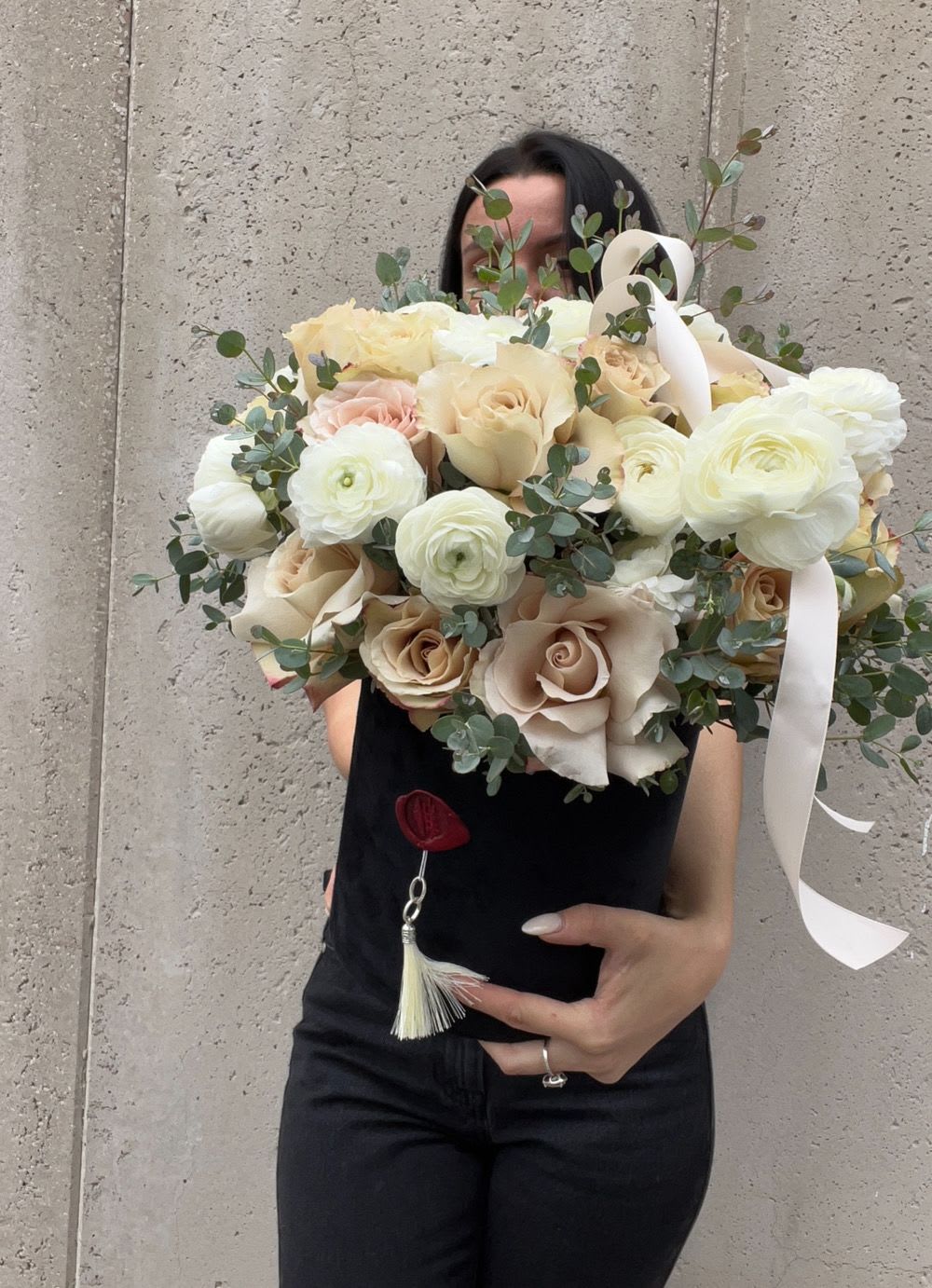 Large bouquet of cream roses and white ranunculus with eucalyptus and ribbon