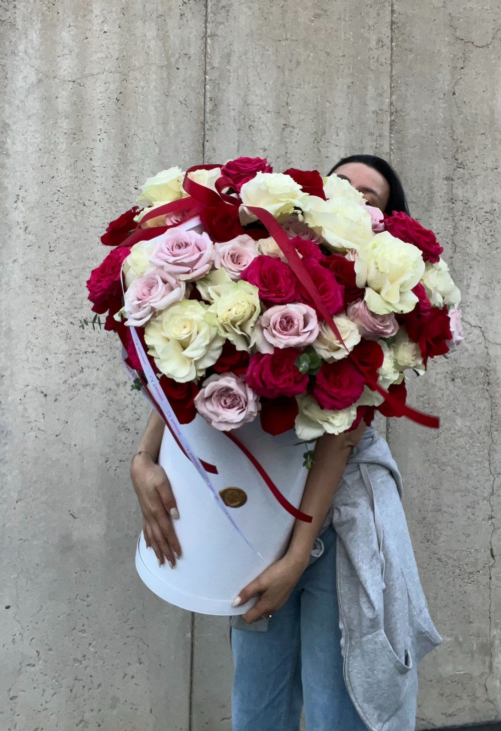 Large bouquet of red, white, and pale pink roses in a white hat box