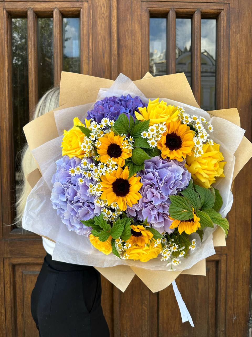 Bouquet of yellow sunflowers, purple hydrangeas, and small white daisies