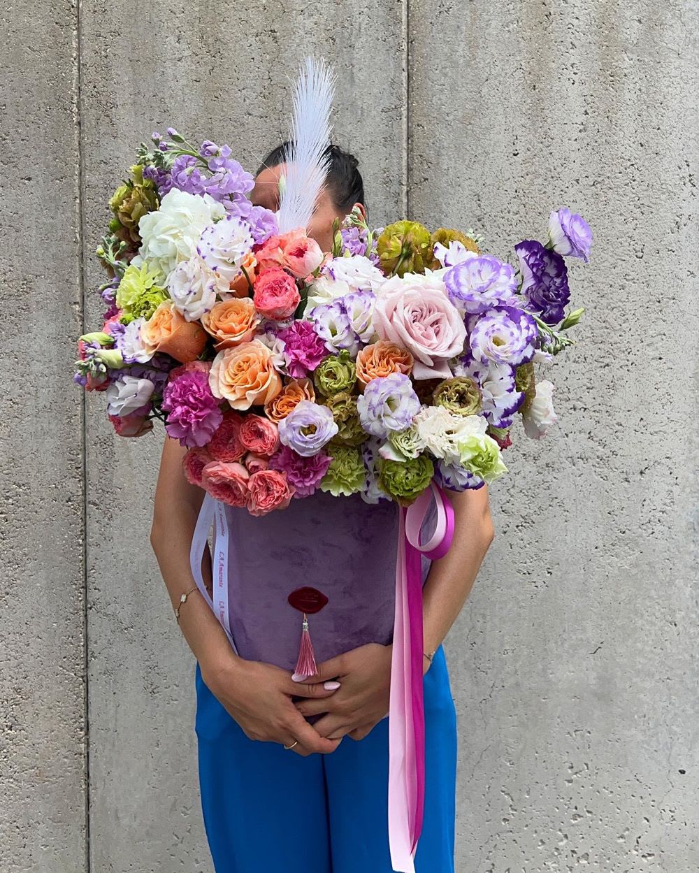 Large bouquet of multicolored roses and lisianthus with ribbon streamers