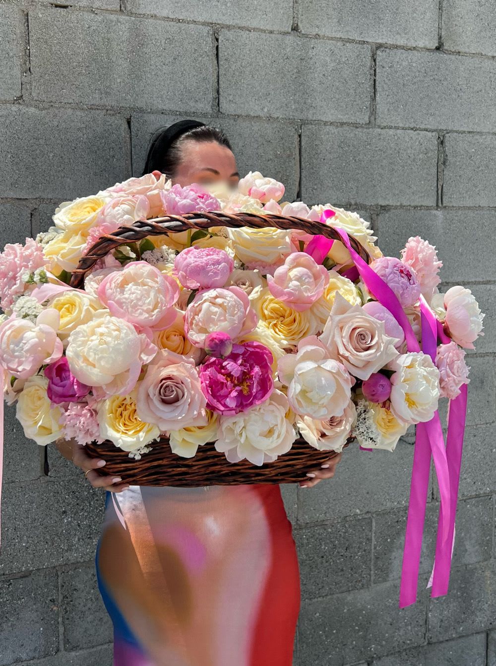 Large basket of pink and cream roses held by a person