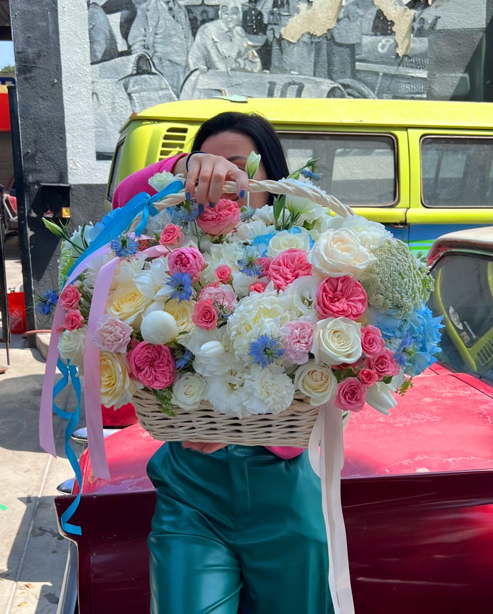 Large basket of pink, white, and blue flowers with ribbon streamers