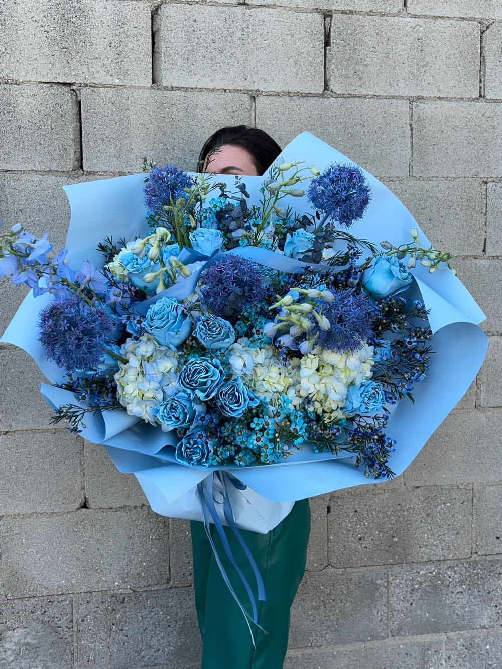 Large blue bouquet with roses, hydrangeas, and round allium blooms