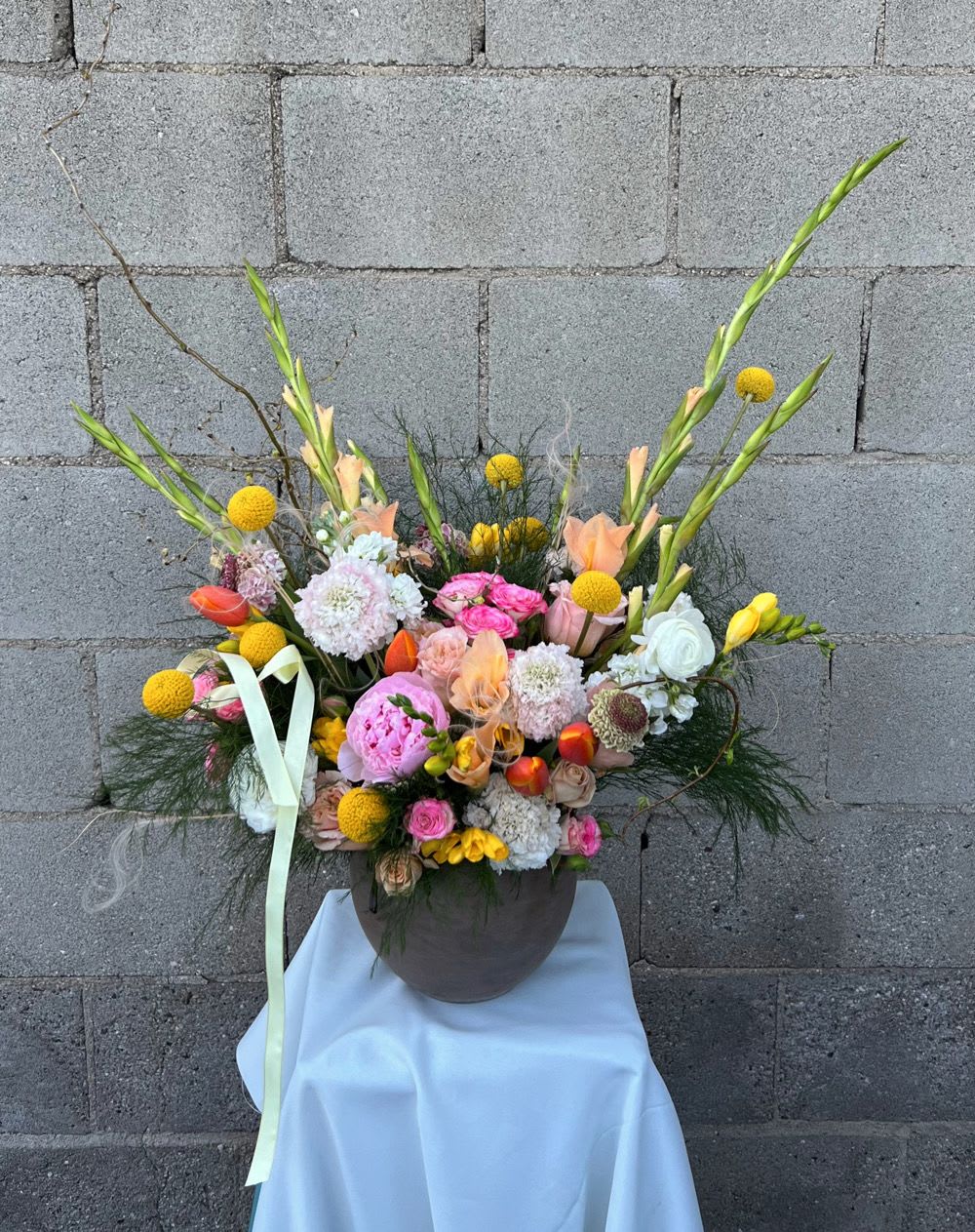 Colorful mixed flower arrangement in a round vase with tall stems