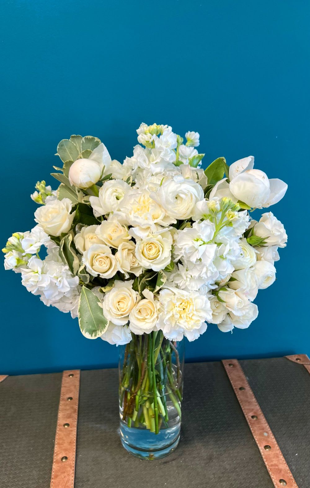 White roses and ranunculus in a clear glass vase