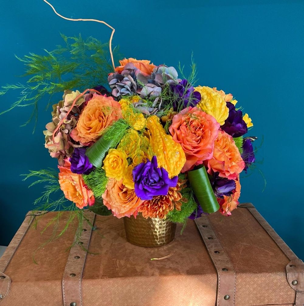 Colorful bouquet of roses and hydrangeas in a gold vase