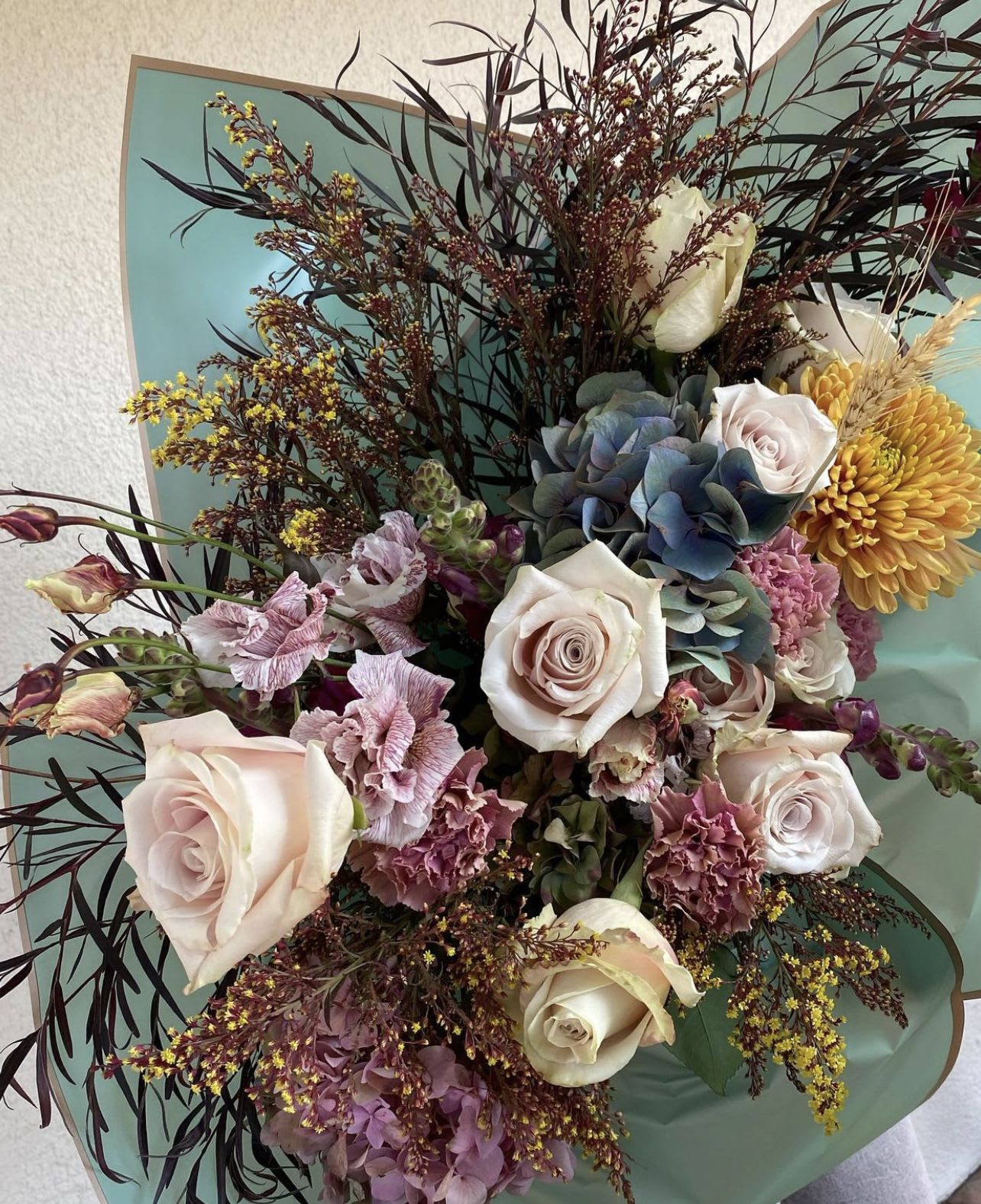 Bouquet of pale roses, hydrangea, and yellow chrysanthemum blooms