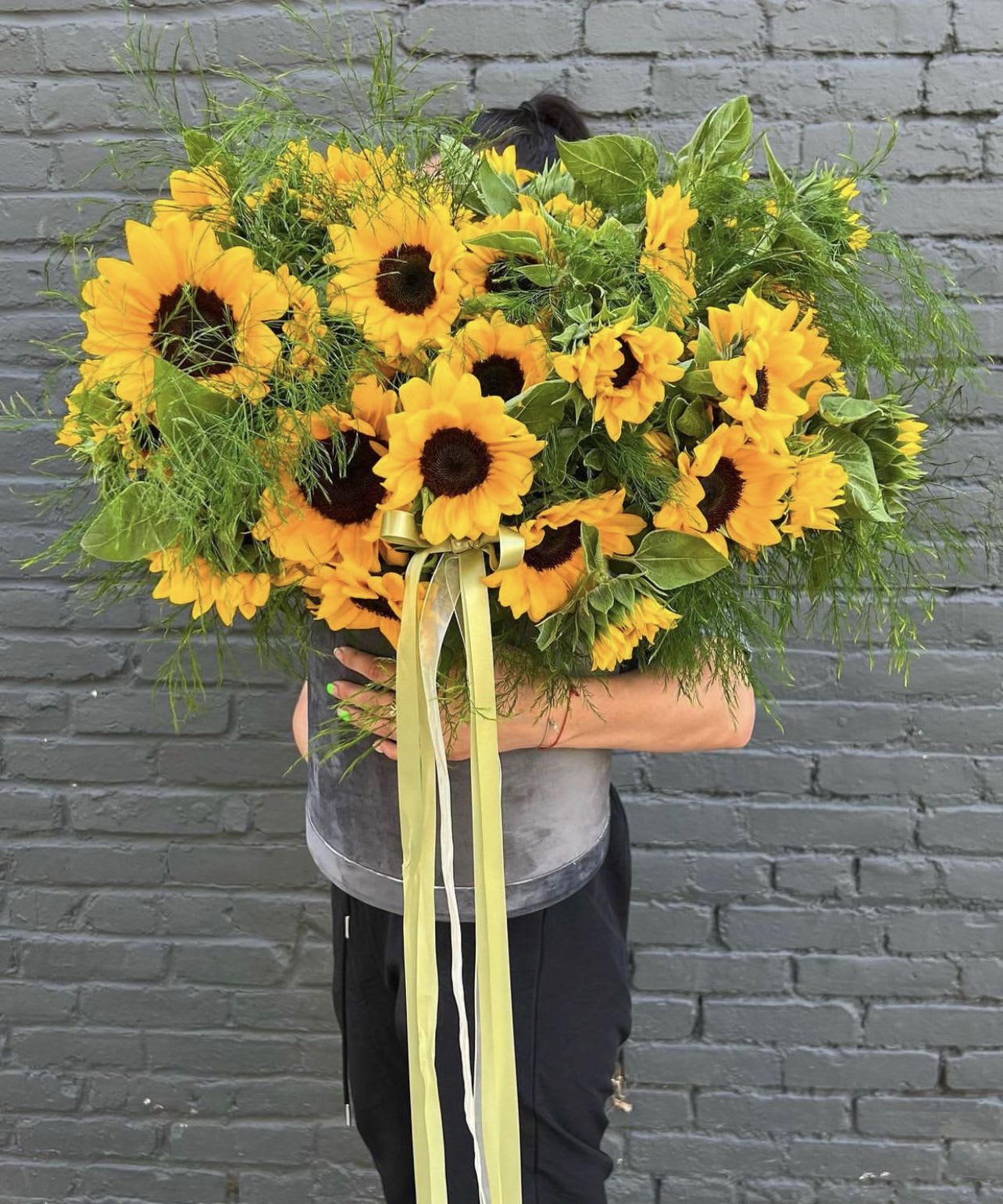 Large bouquet of yellow sunflowers with a ribbon tie