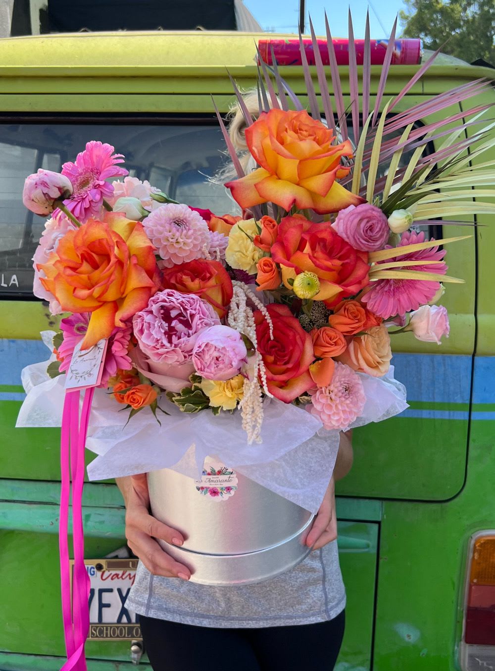 Large mixed bouquet in a silver hatbox with bright orange roses and pink blooms