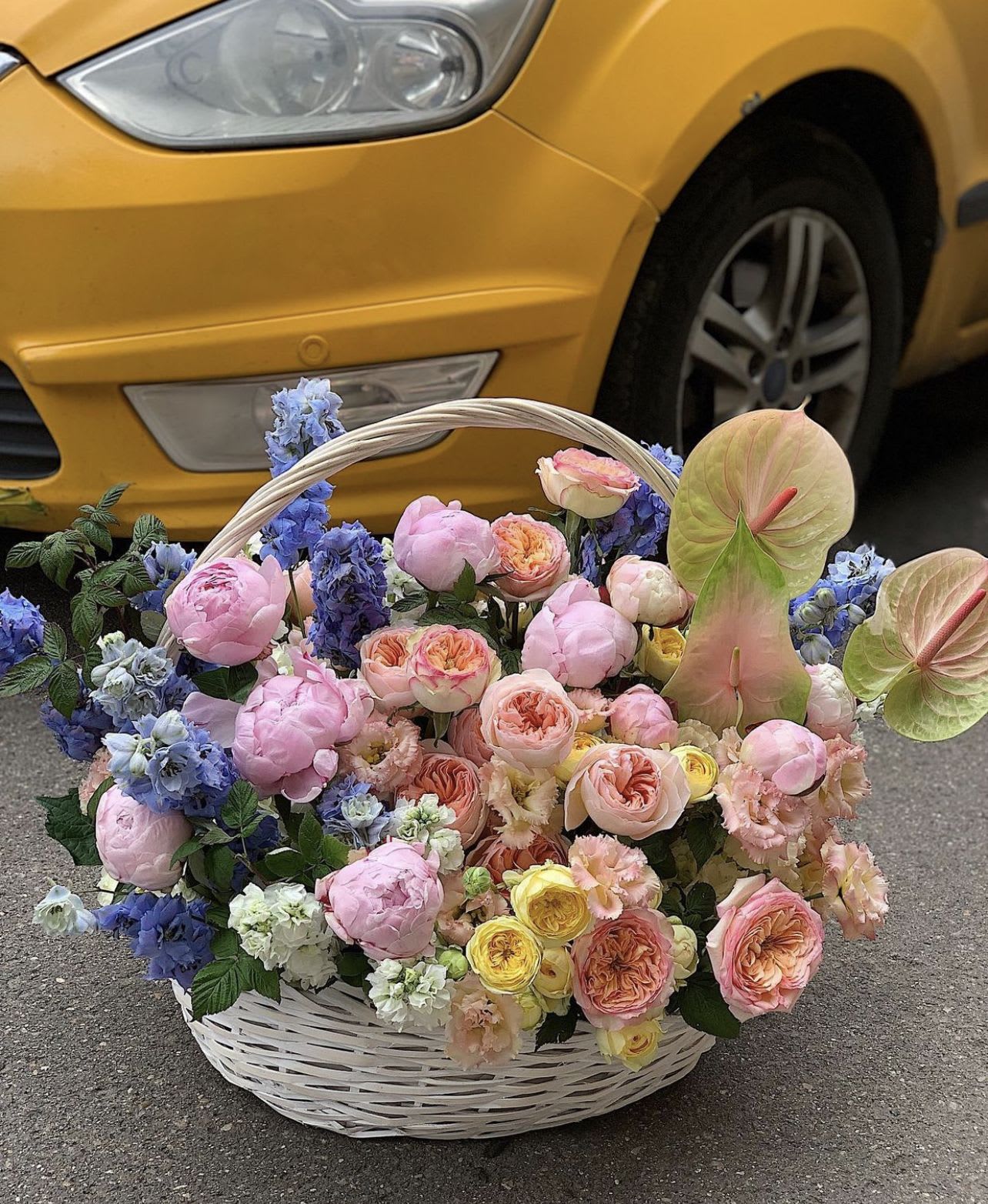 Large basket of pastel flowers with pink roses and blue blooms