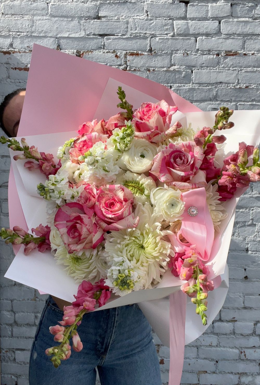 Bouquet of pink and white flowers wrapped in pink paper