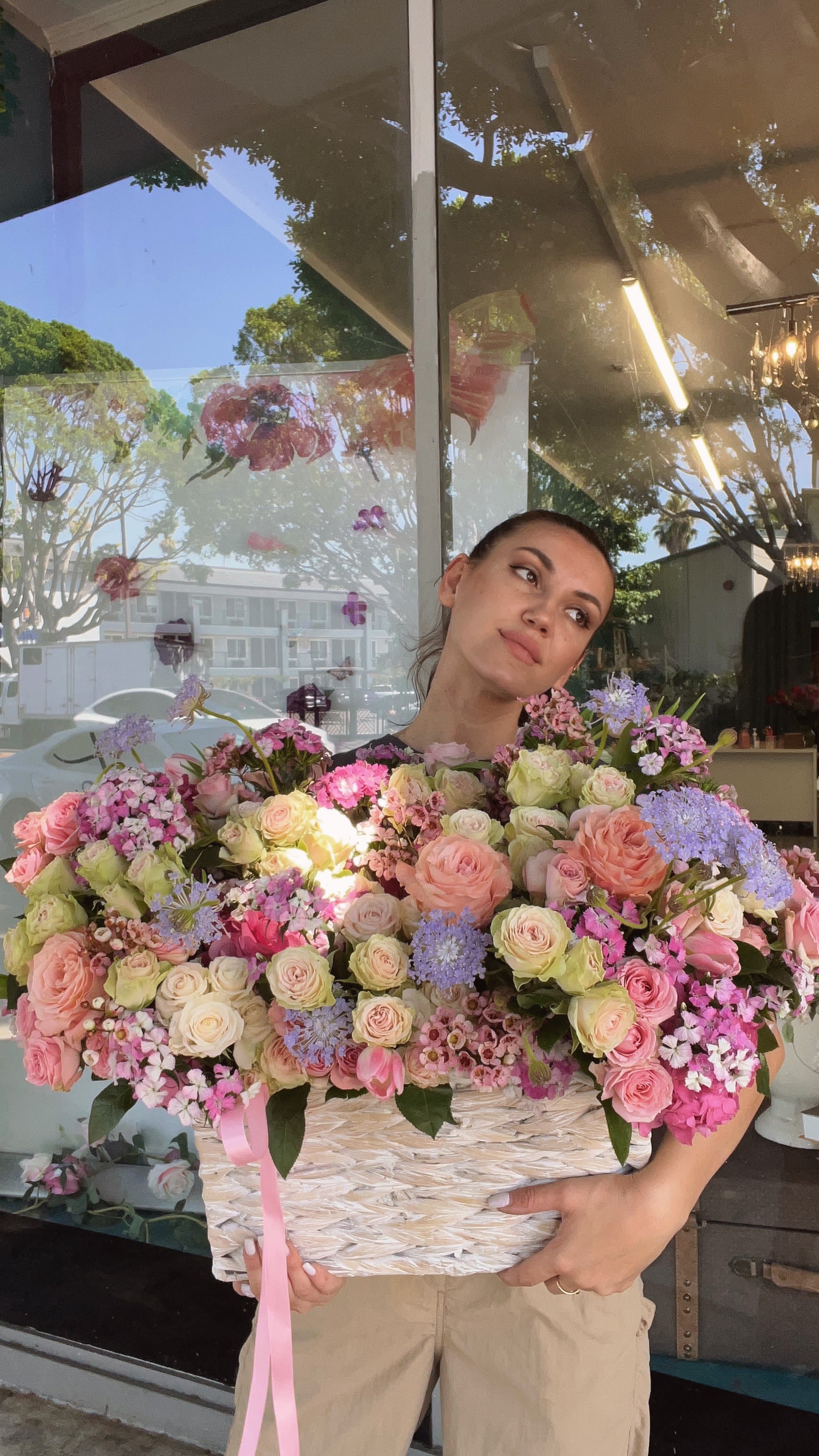 Large basket arrangement of pink and cream roses with lavender flowers