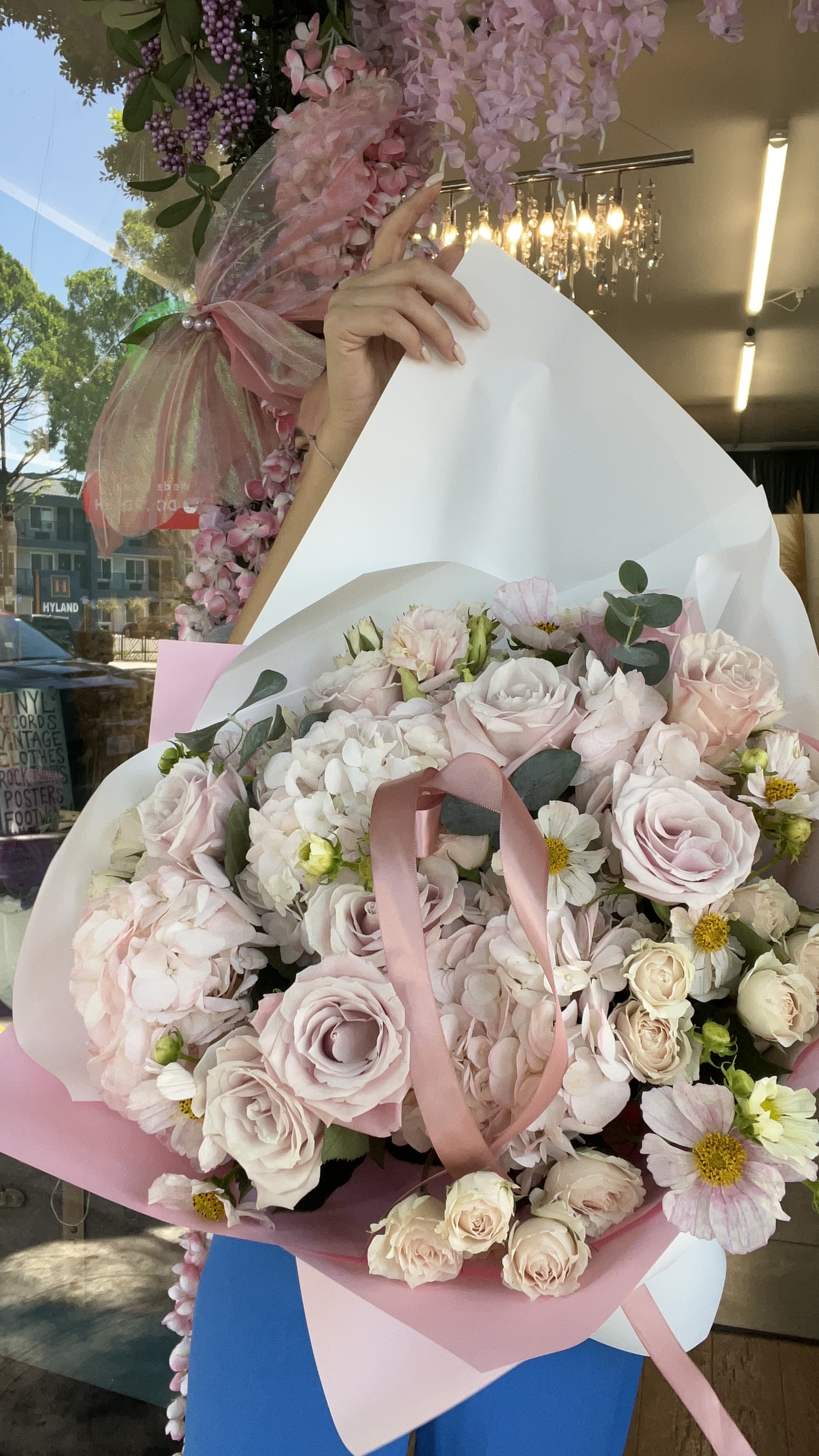 Bouquet of pale pink roses and white flowers wrapped in pink paper