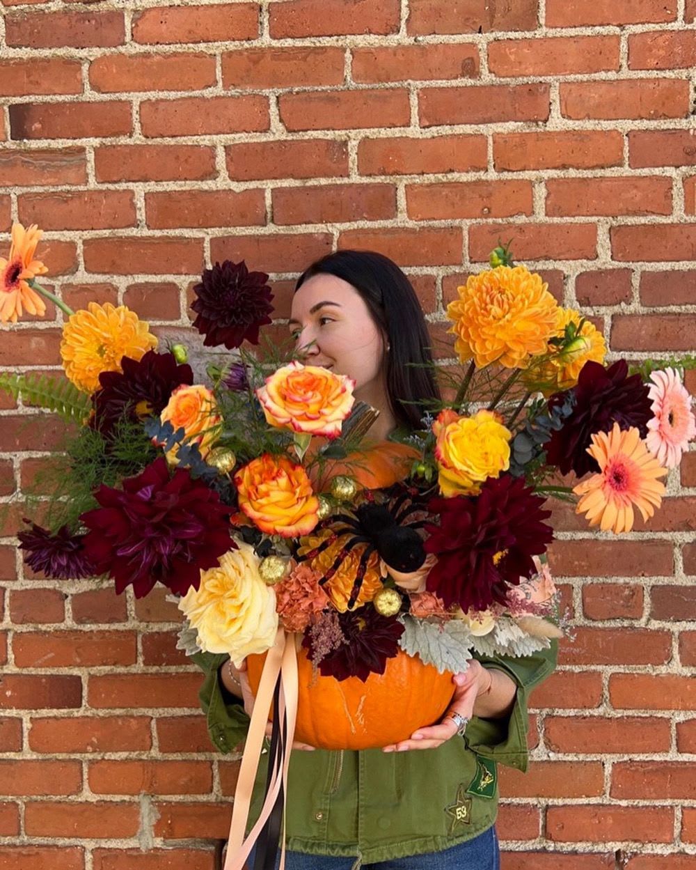 Woman holding a pumpkin filled with colorful flowers