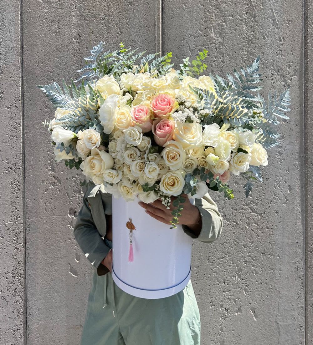 Large bouquet of cream and blush roses in a white hatbox
