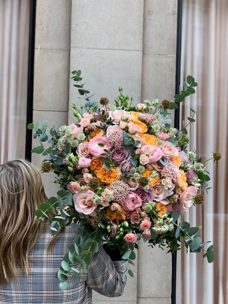 Large bouquet of pink, peach, and lavender roses with eucalyptus