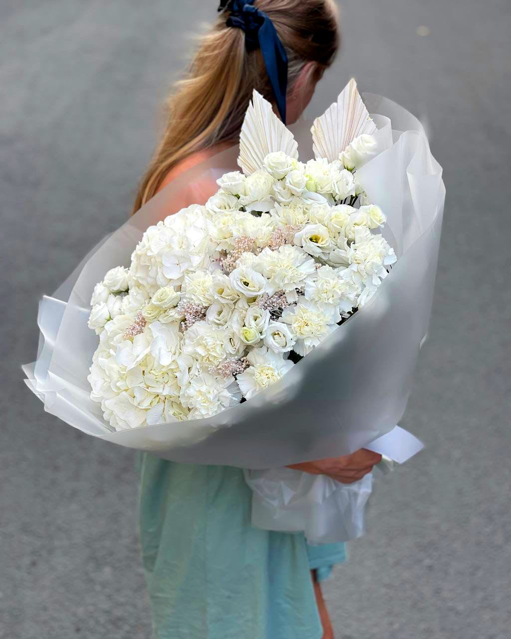 Large white bouquet wrapped in translucent paper
