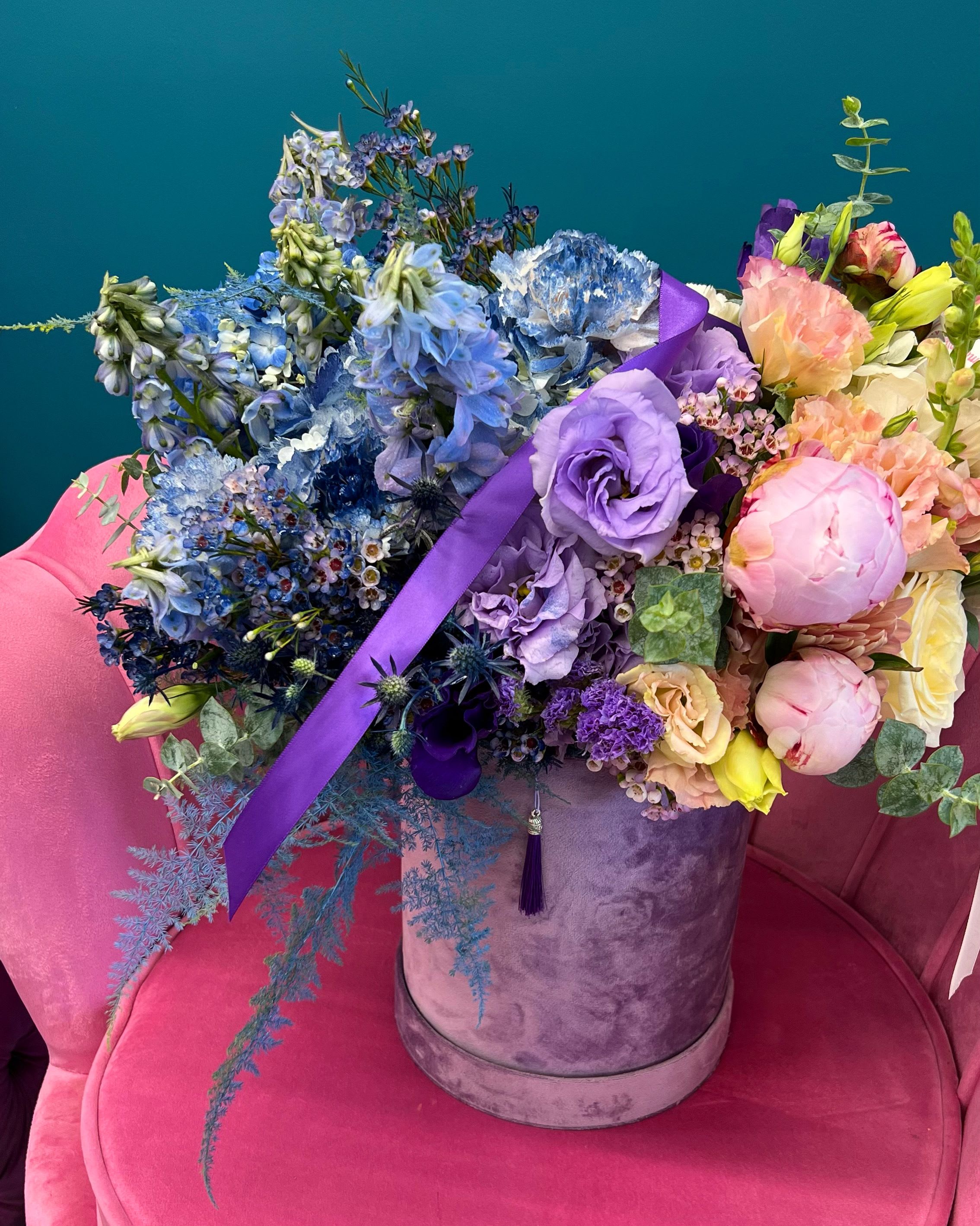 Large mixed bouquet in a lavender hatbox with blue, purple, and pink flowers