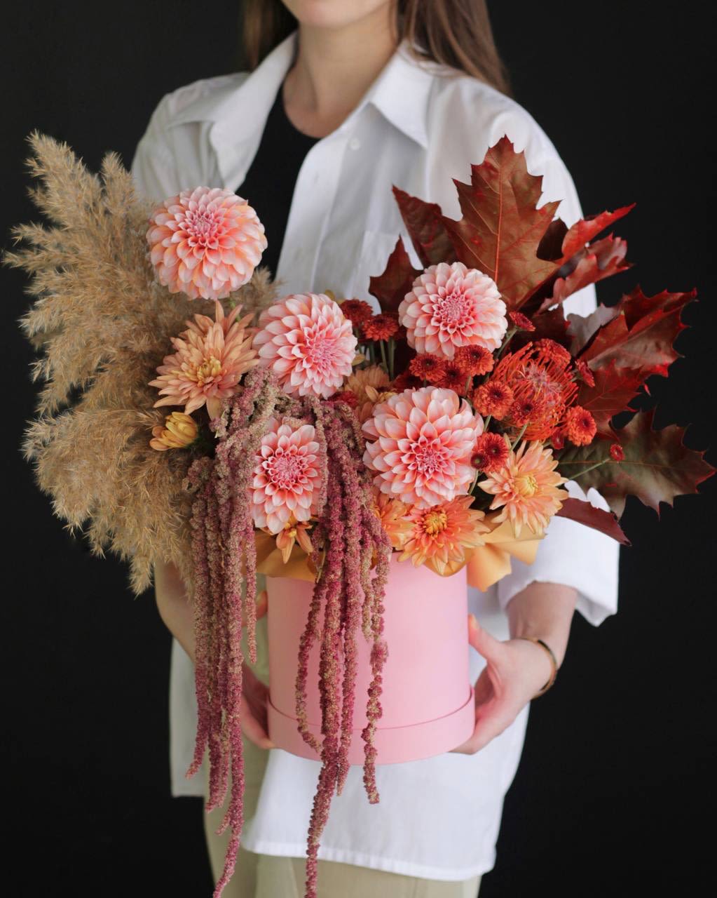 Pink and peach floral arrangement in a round pink box